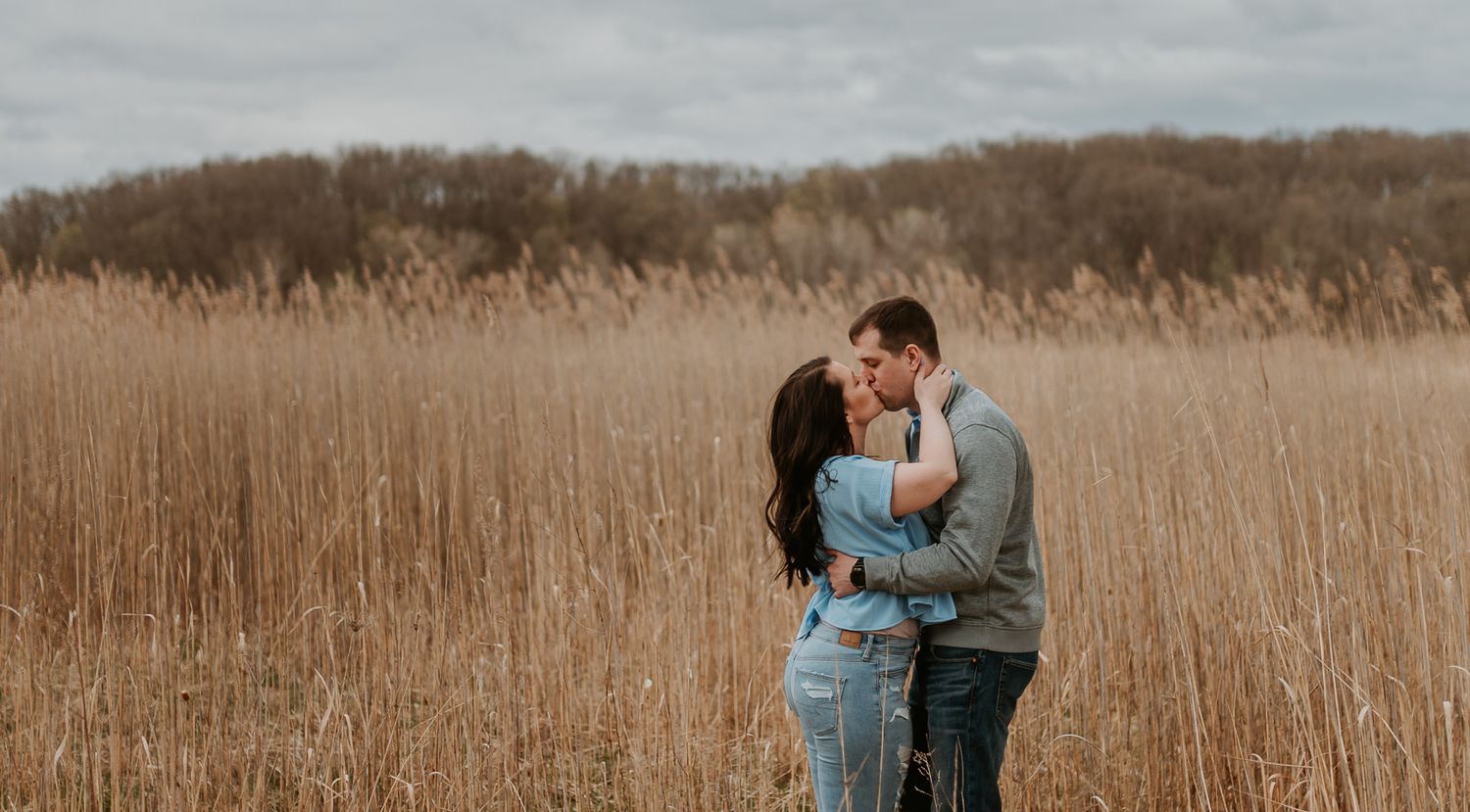 Intimate moments captured in a rustic field setting under overcast skies.