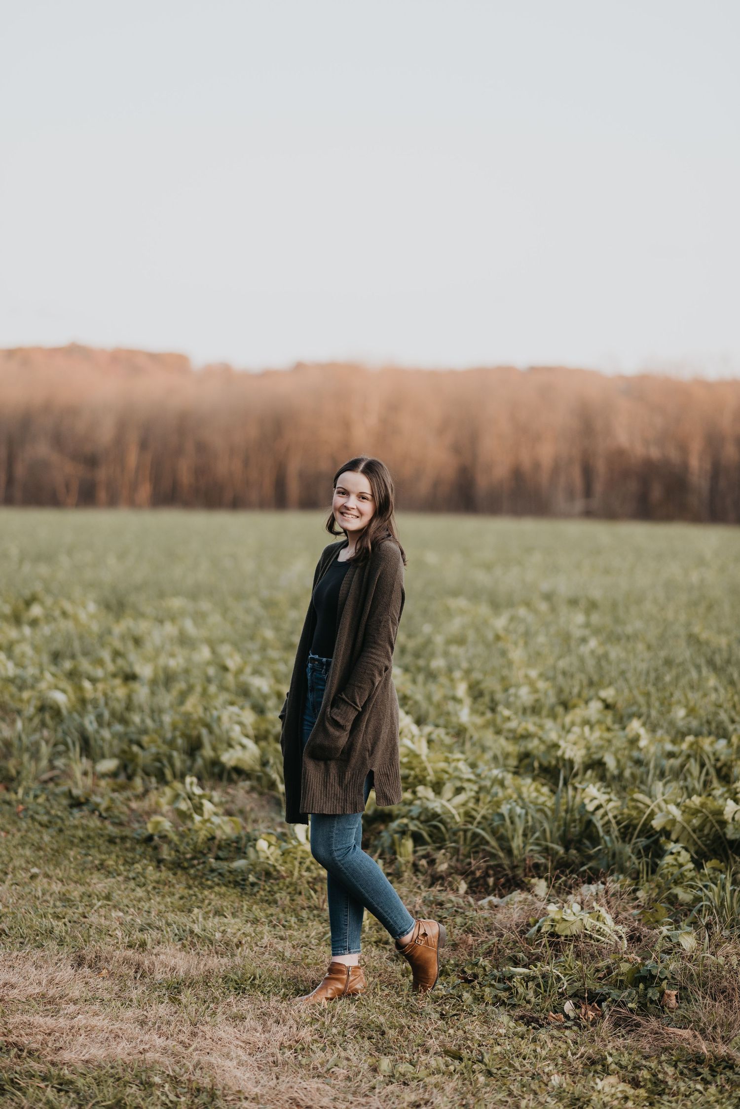 A series of photos showing a person enjoying an autumn day in a field of green grass and distant brown trees.