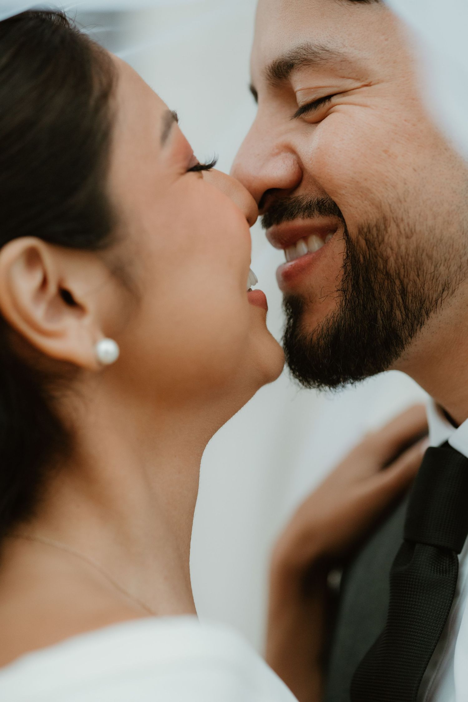 Close-up romantic portrait of a couple in wedding attire sharing an intimate moment.