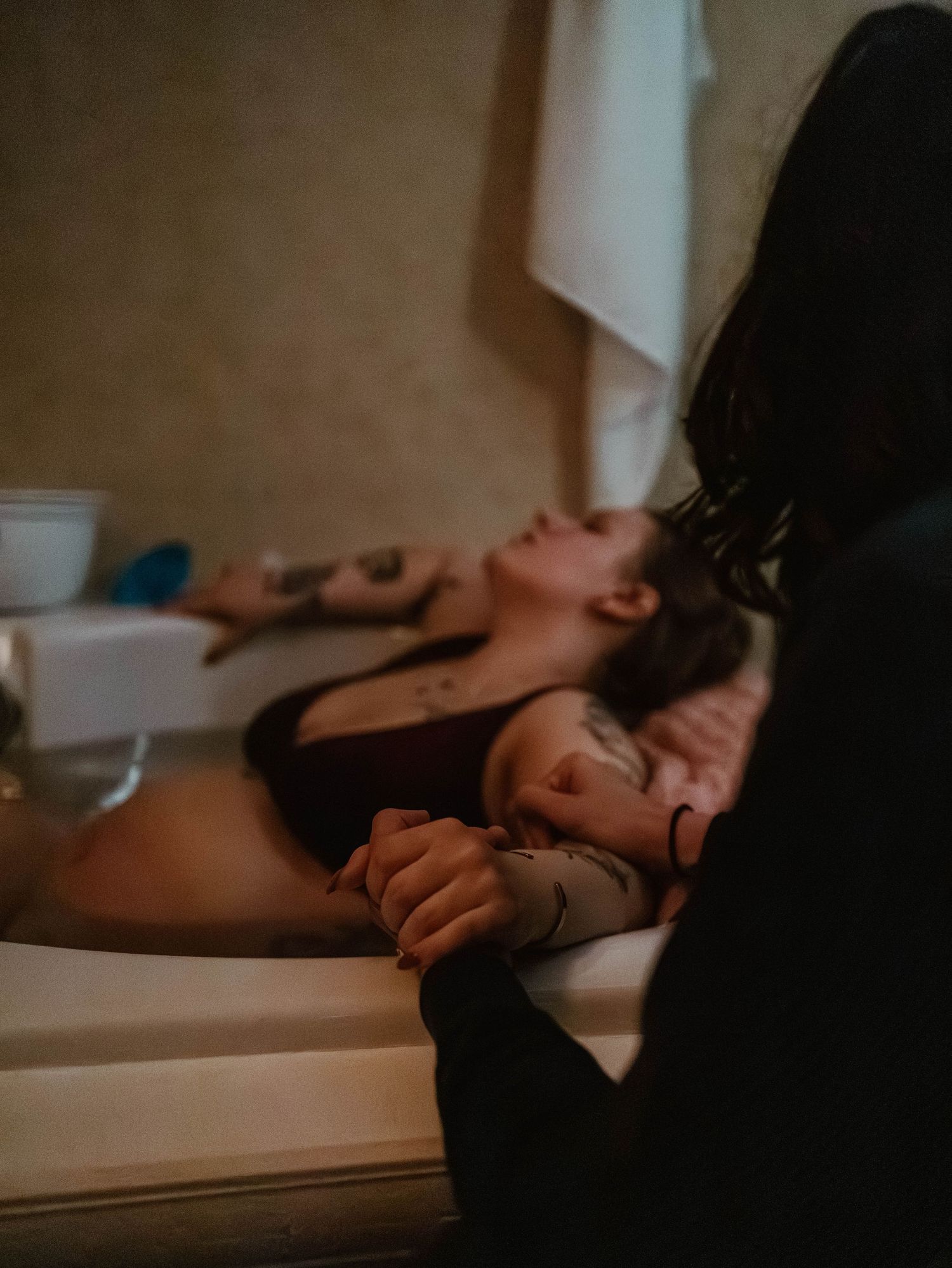 Person laying back on bathroom counter in dim lighting during a relaxing spa treatment session.