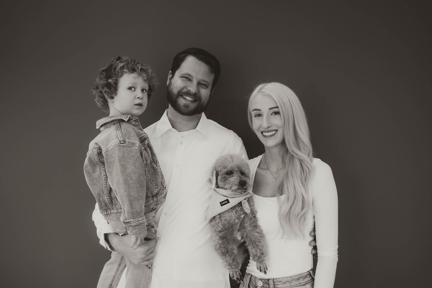 Group portrait of parents and child in matching outfits during a casual photo session.