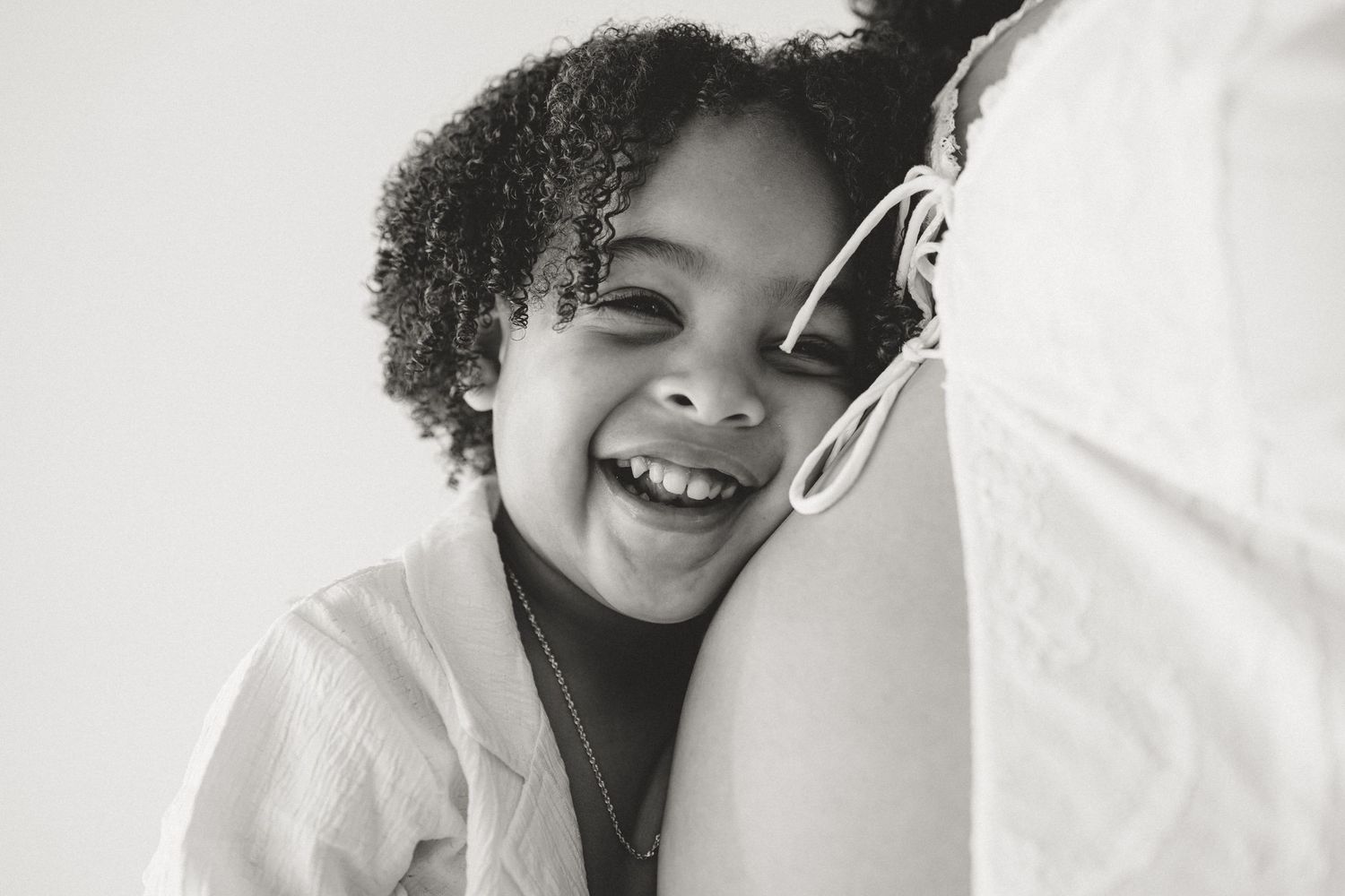 Monochrome sequence captures someone smiling and showing off their curly hair in different poses.
