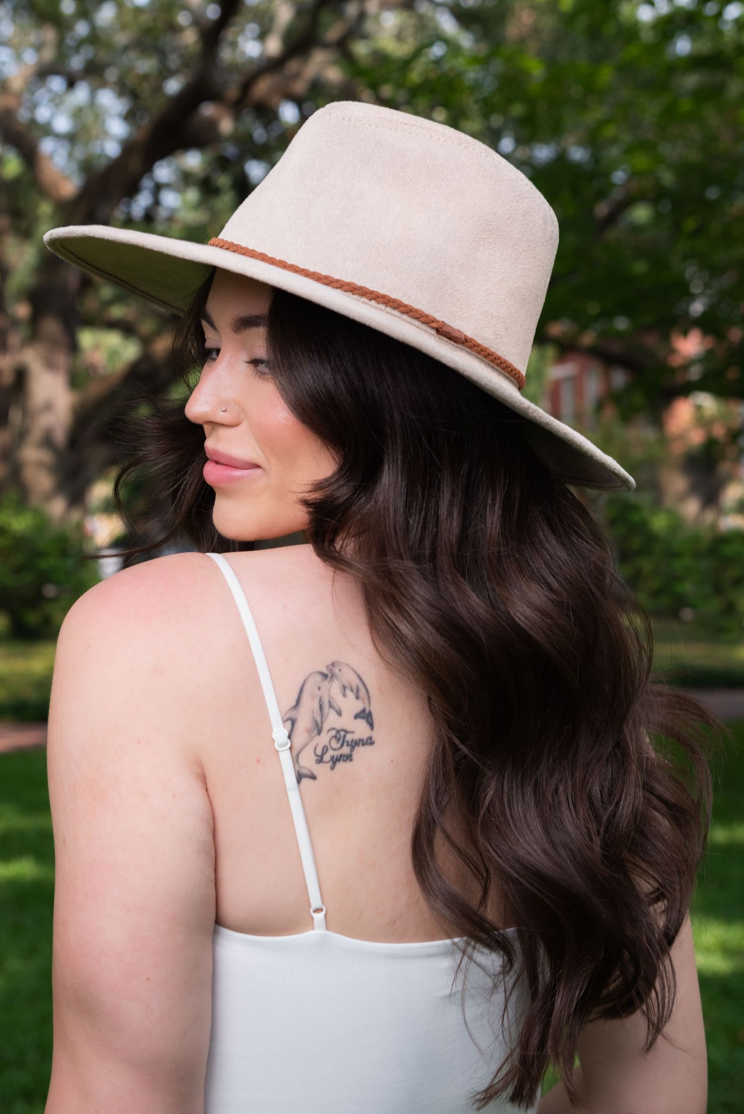 A series of artistic profile shots showing a person wearing a light fedora hat and white tank top against a blurred nature backdrop.