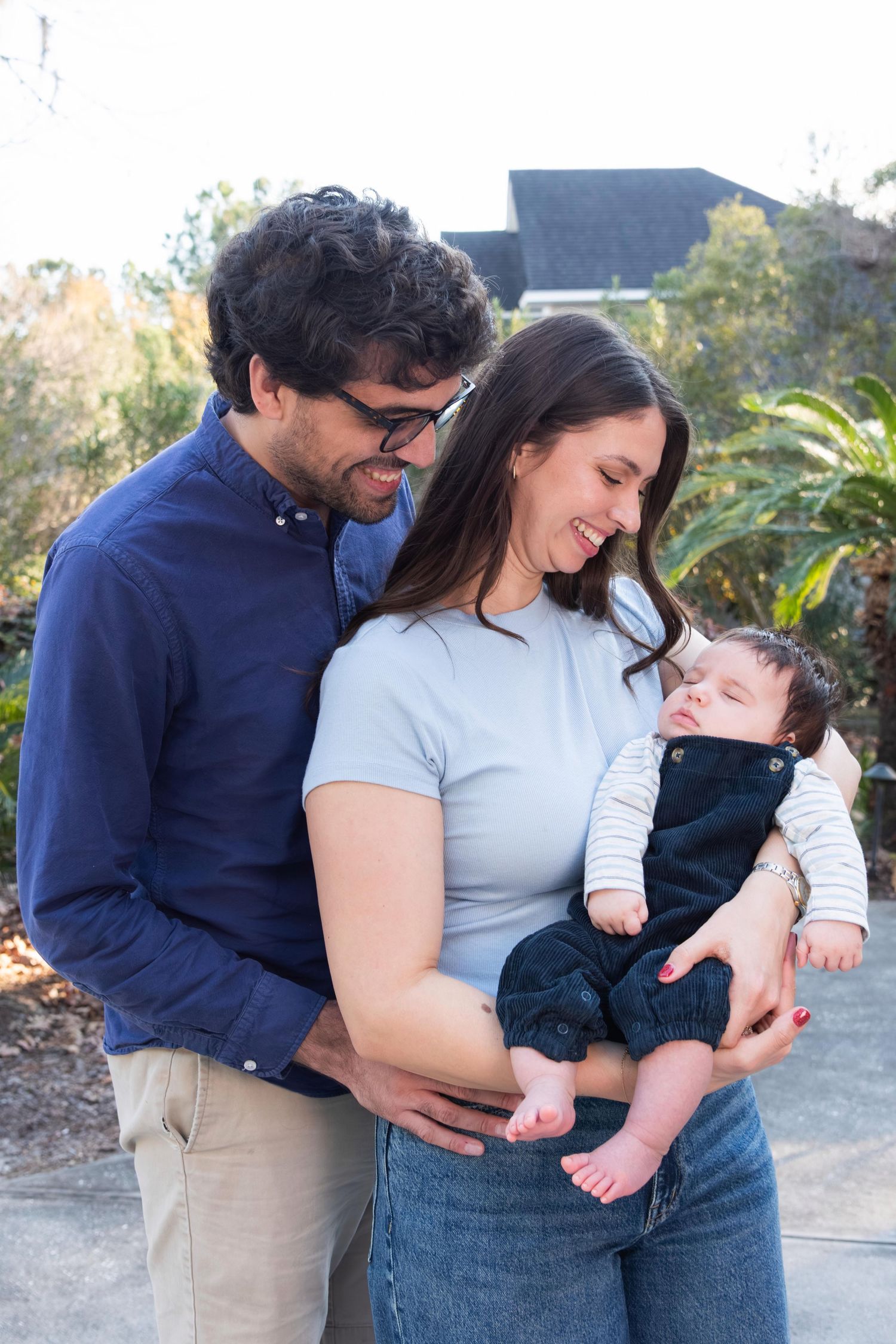 A couple shares tender moments with their baby outdoors in a series of candid family photos.