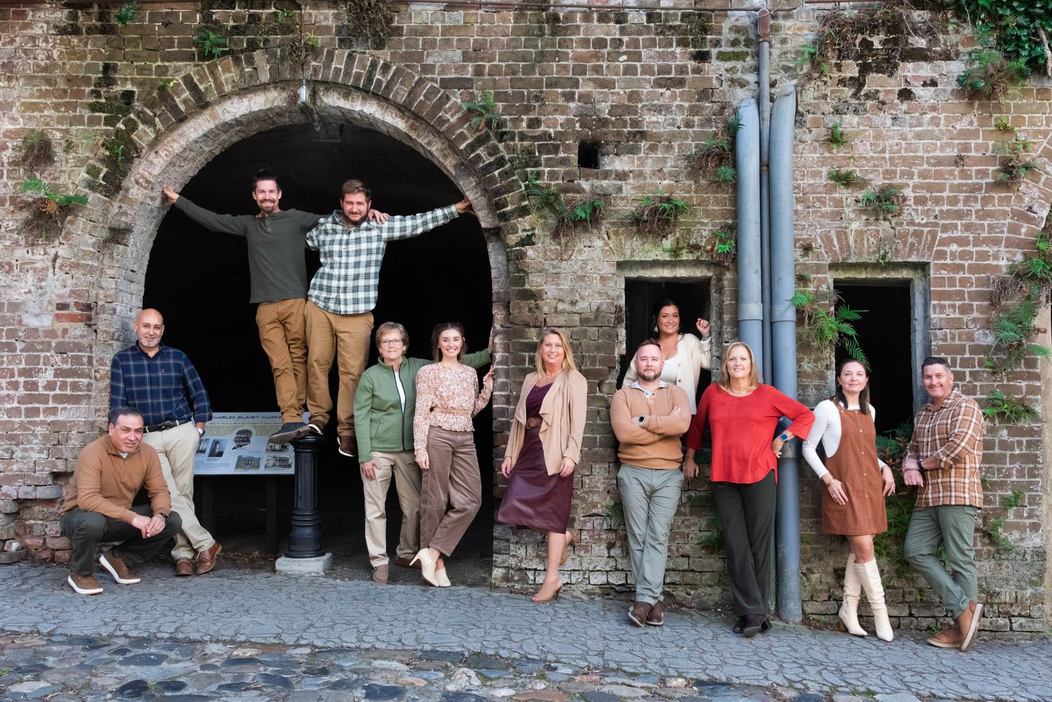 A group of people sit casually against a rustic brick wall in a series of candid shots.