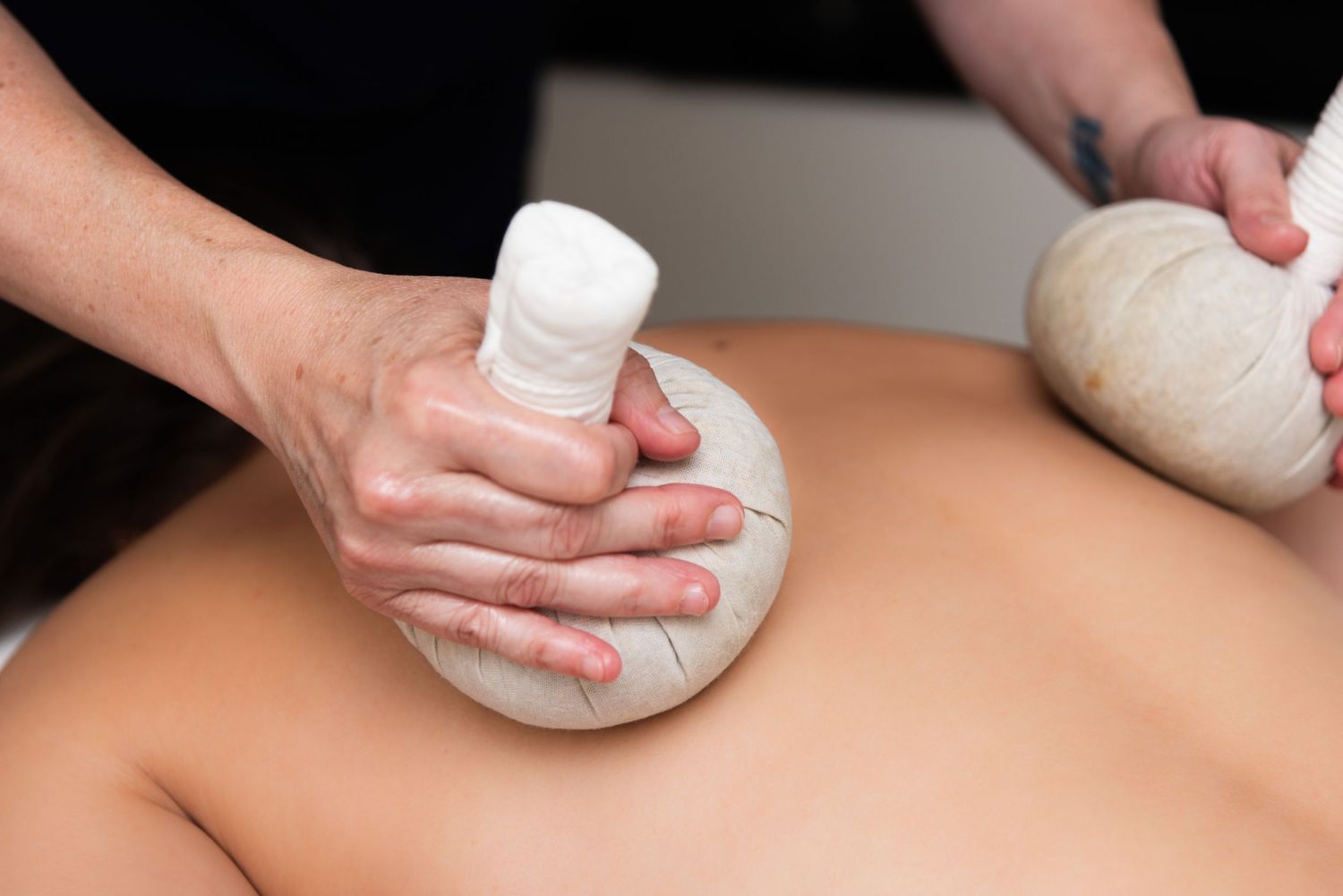 A sequence of hands performing Thai massage therapy techniques with herbal compress balls on a person's back.