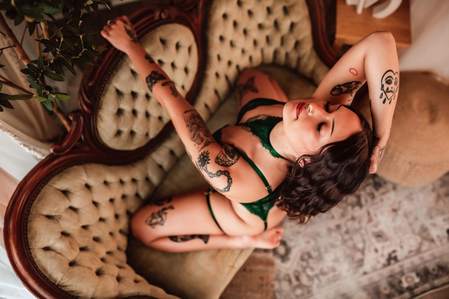 Indianapolis Indiana luxury boudoir portrait of client touch hair in emerald green bodysuit with natural lighting