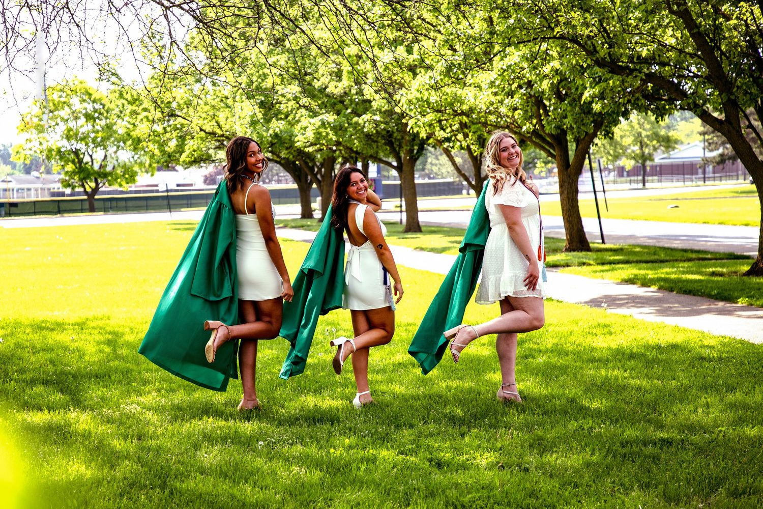 People walking with green flags across a sunny lawn during an outdoor event.