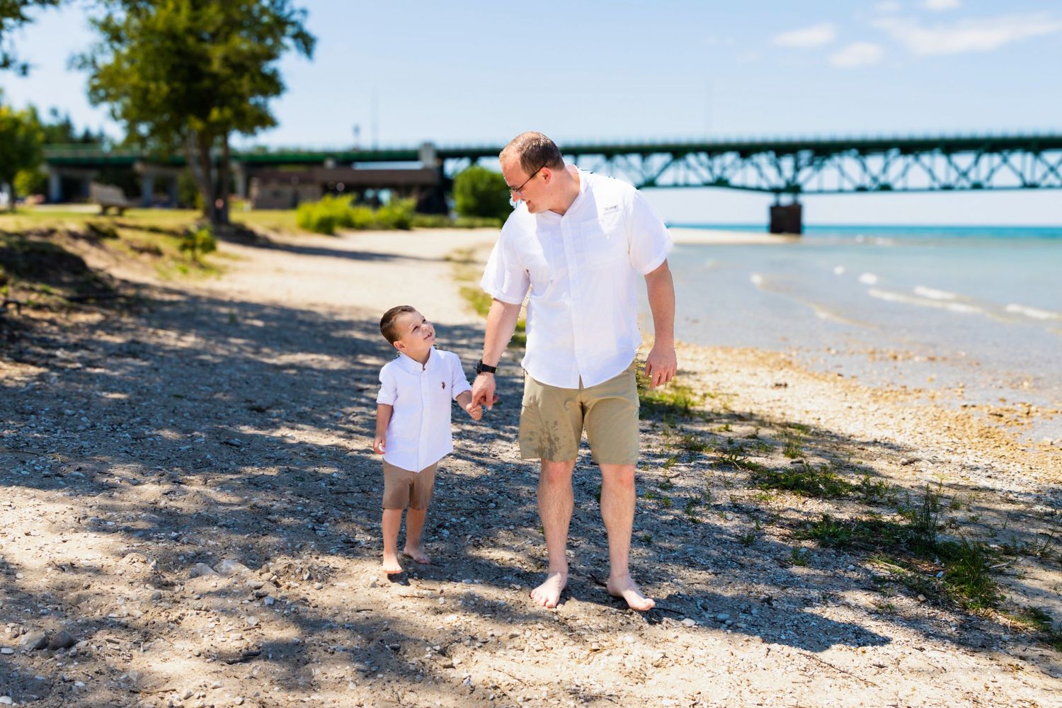Beach photography session with scenic Lake Michigan and bridge in background.