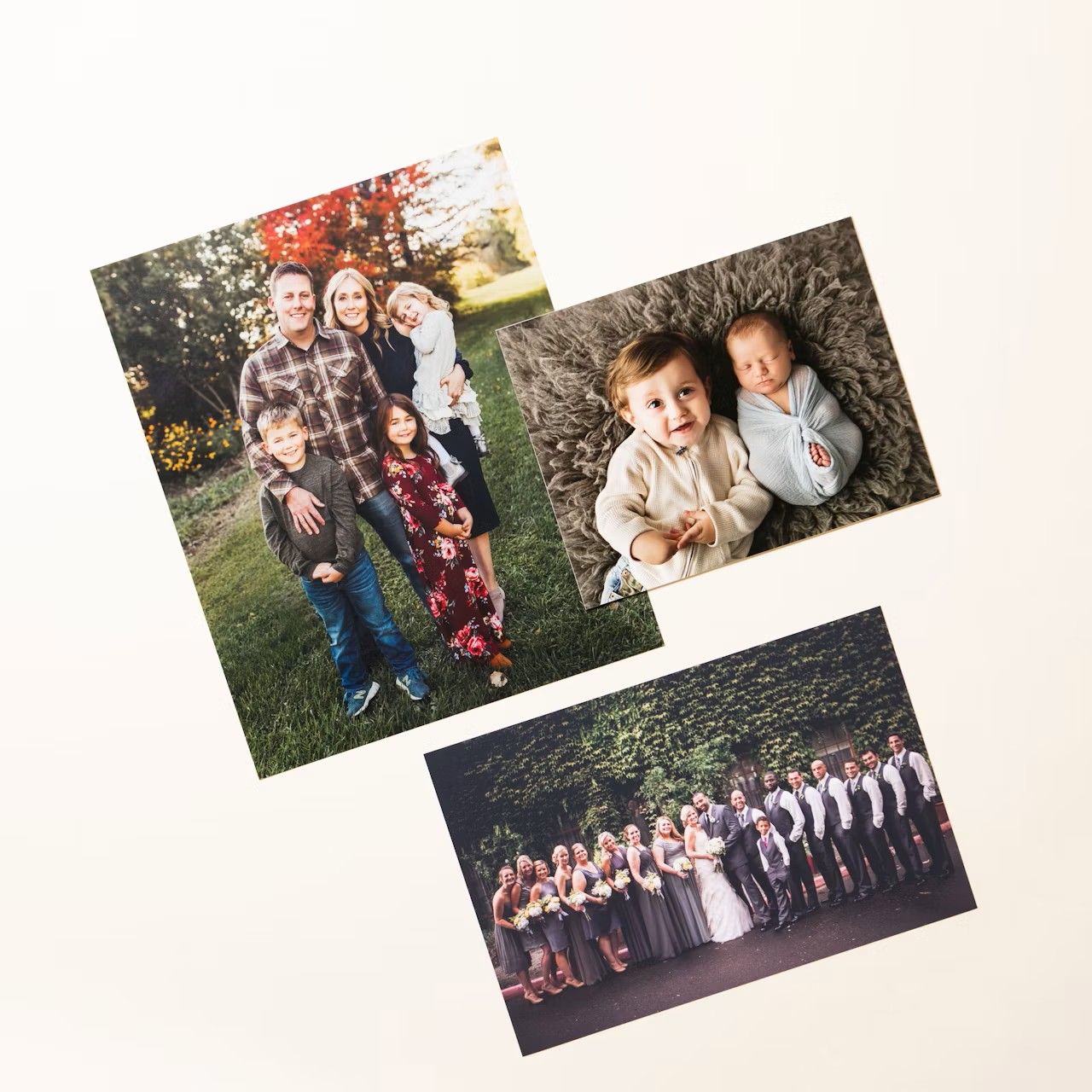 Three printed photos showing a family portrait, two babies on grass, and a wedding party group photo displayed on white background.
