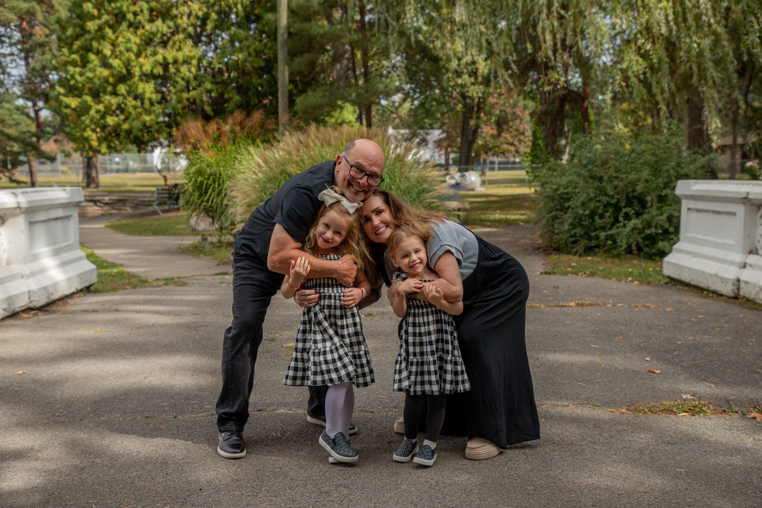 Family sharing playful moment together in park on sunny day.