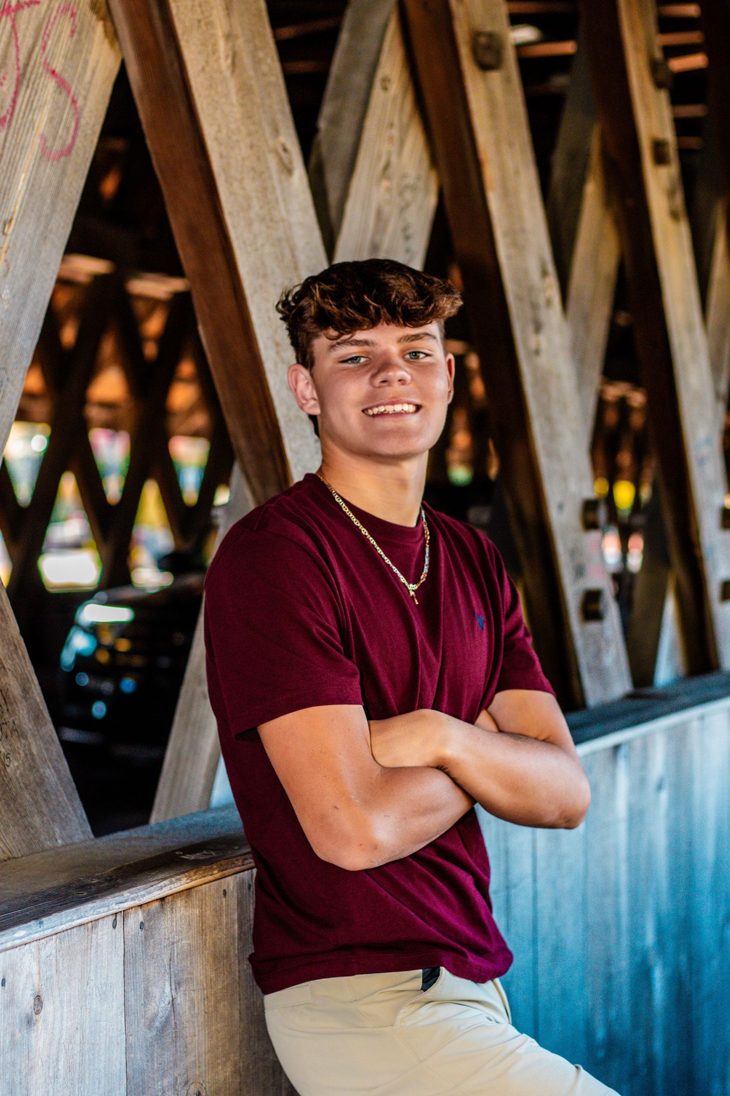 A casual portrait in a covered wooden bridge with natural lighting.