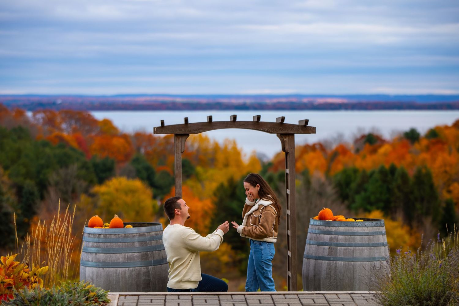 Couple enjoying autumn views from a scenic overlook with colorful fall foliage in the background.