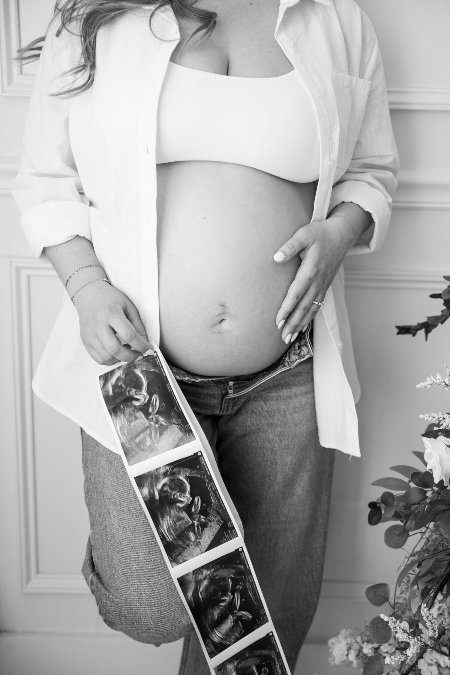 Black and white pregnancy progression photos showing growing baby bump with ultrasound images.
