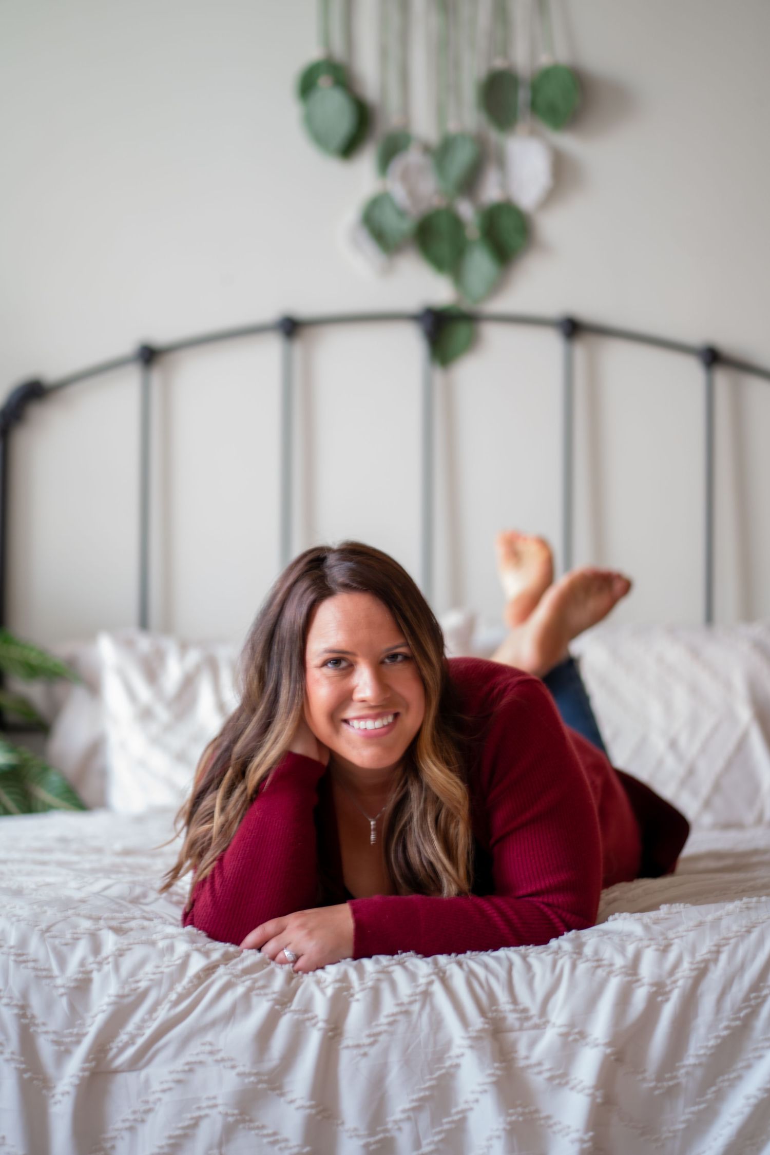 Lifestyle photography on white bedding with hanging plants and natural window light.