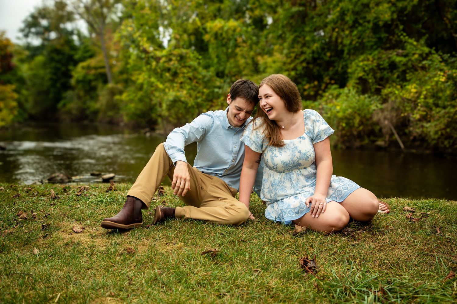 Romantic couple relaxing together on lush green grass in a natural outdoor setting.