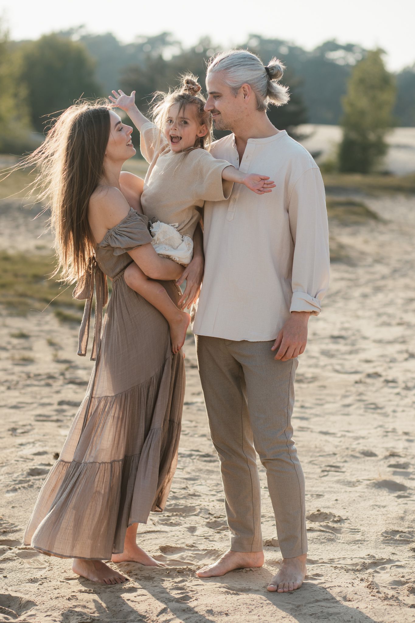 Een ontspannen gezinsmoment tijdens een familieshoot in het Wekeromse Zand, waar liefde, verbinding en plezier centraal staan.