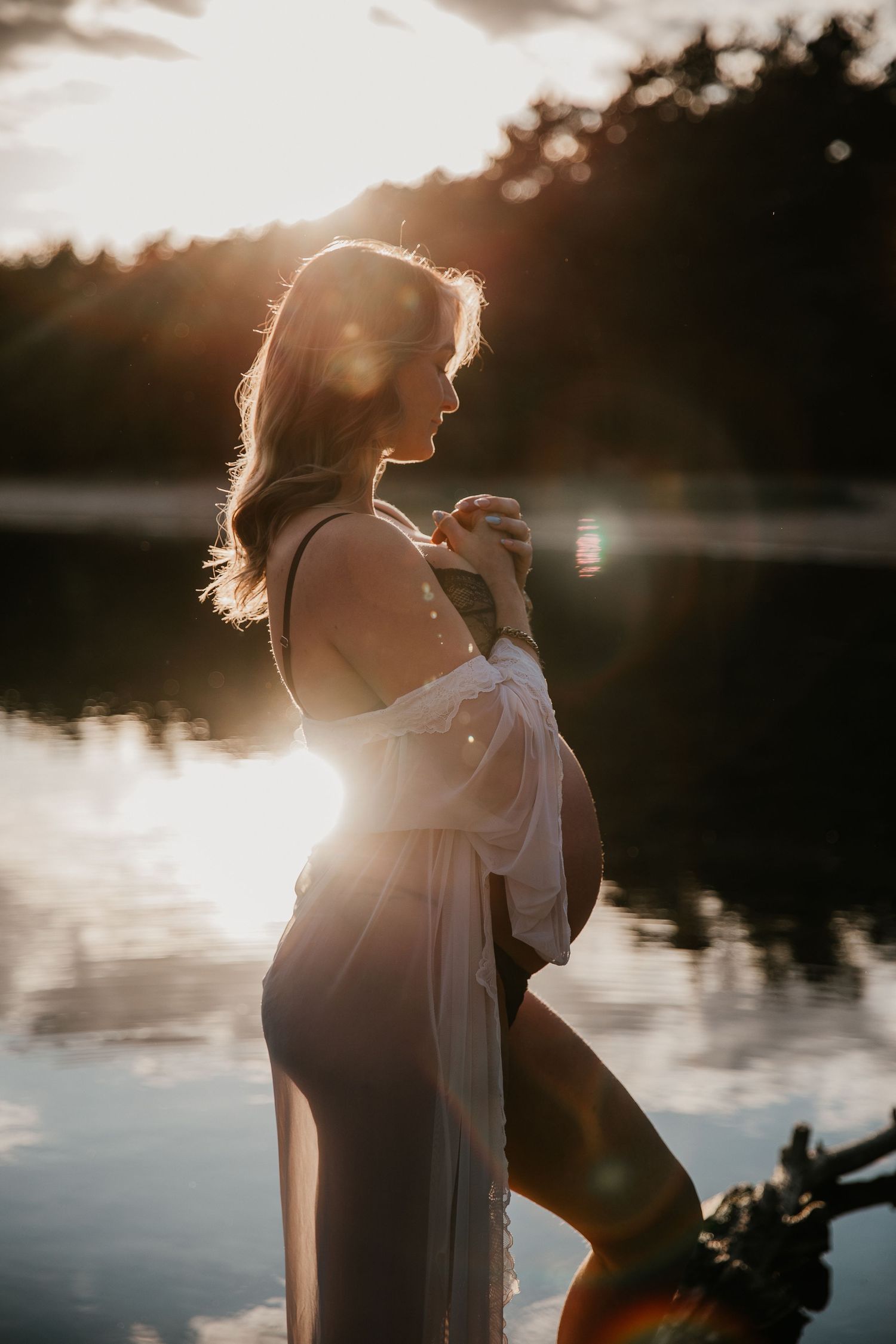 Een zwangere mama straalt tijdens een liefdevolle zwangerschapsshoot tijdens gouden uur, omringd door het warme licht.
