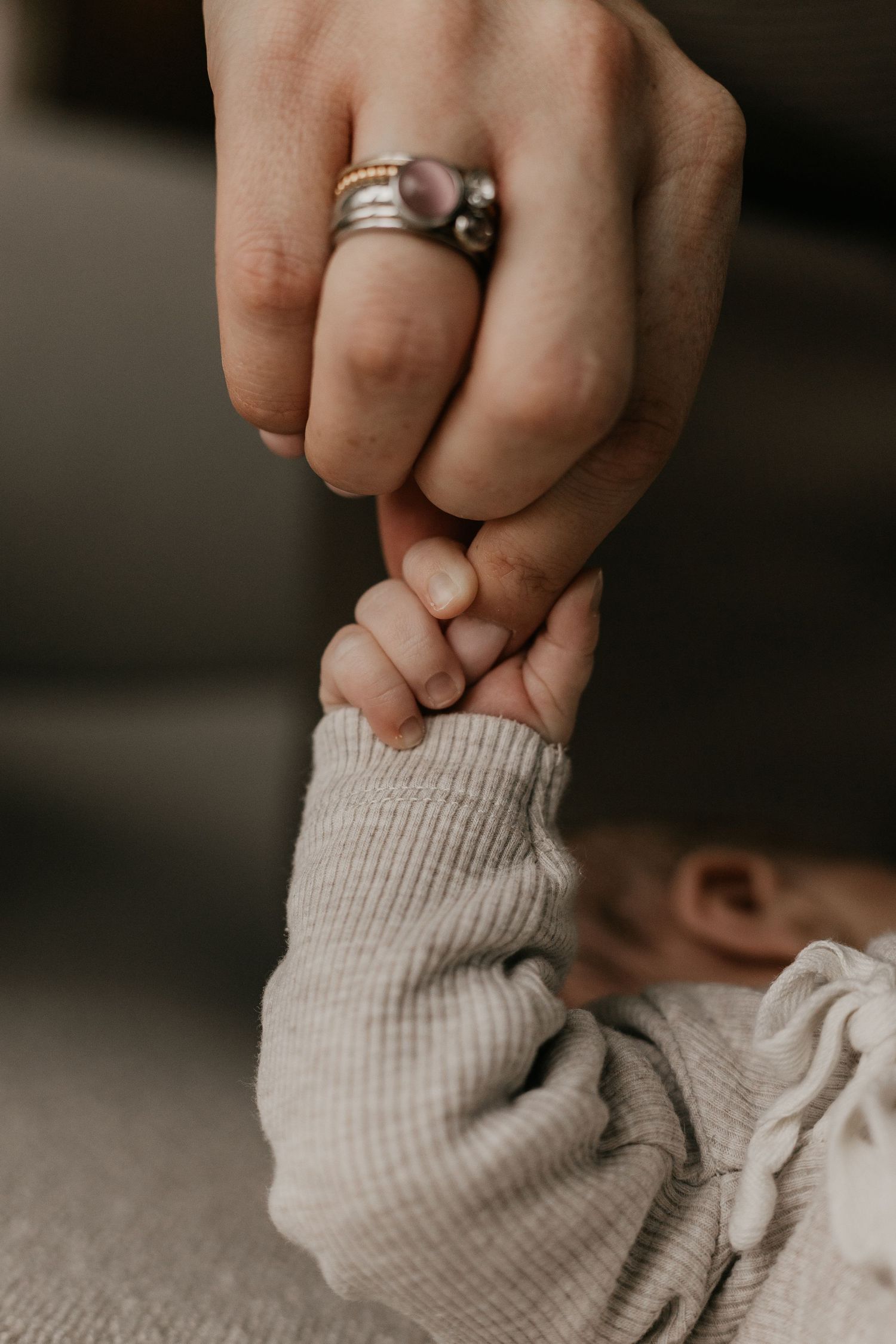 Newborn baby tijdens een ontspannen fotoshoot aan huis, waarbij de warme en vertrouwde omgeving van het gezin wordt vastgelegd.