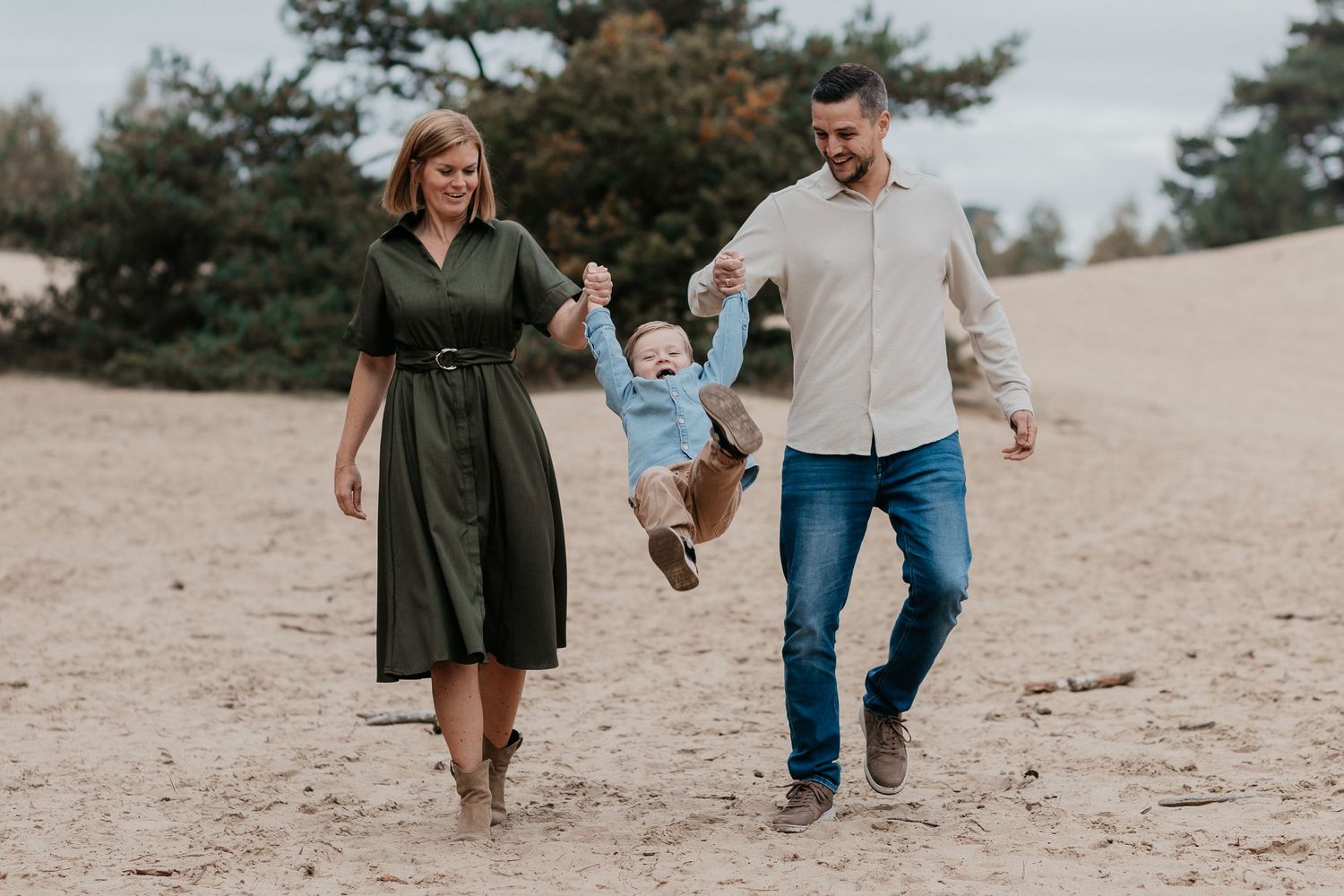 Een ontspannen gezinsmoment tijdens een familieshoot in het Wekeromse Zand, waar liefde, verbinding en plezier centraal staan.
