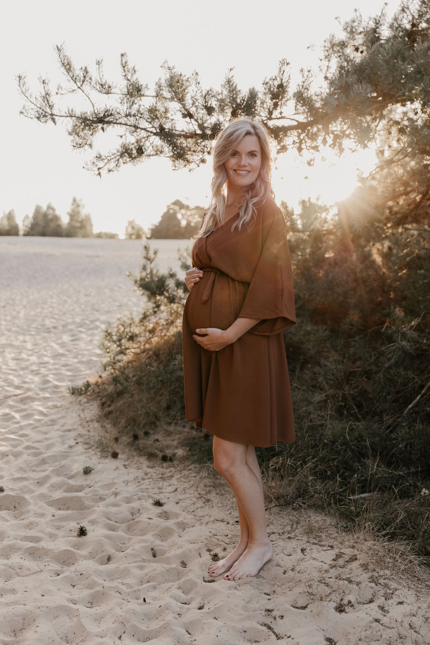 Een aanstaande mama straalt tijdens een warme zwangerschapsshoot bij het Wekeromse Zand, omringd door de rust en schoonheid van de natuur.