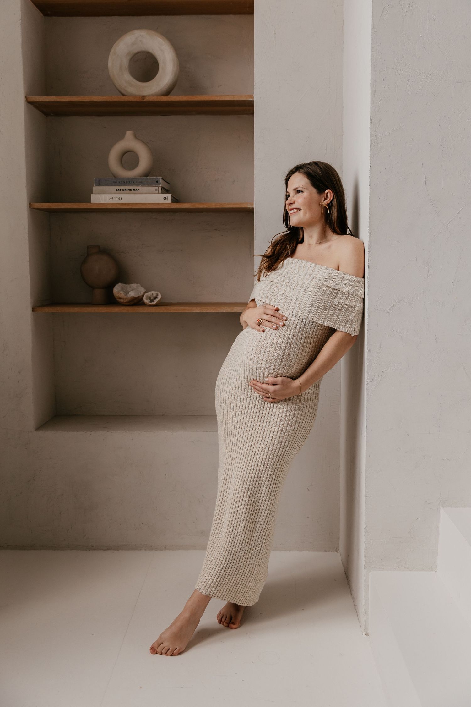 Een aanstaande mama geniet van haar zwangerschap tijdens een liefdevolle fotoshoot in een studio, een bijzonder moment.