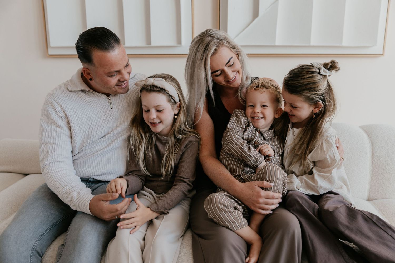 Warme familiefotografie waarbij ouders en kinderen samen genieten van een ontspannen moment in studio