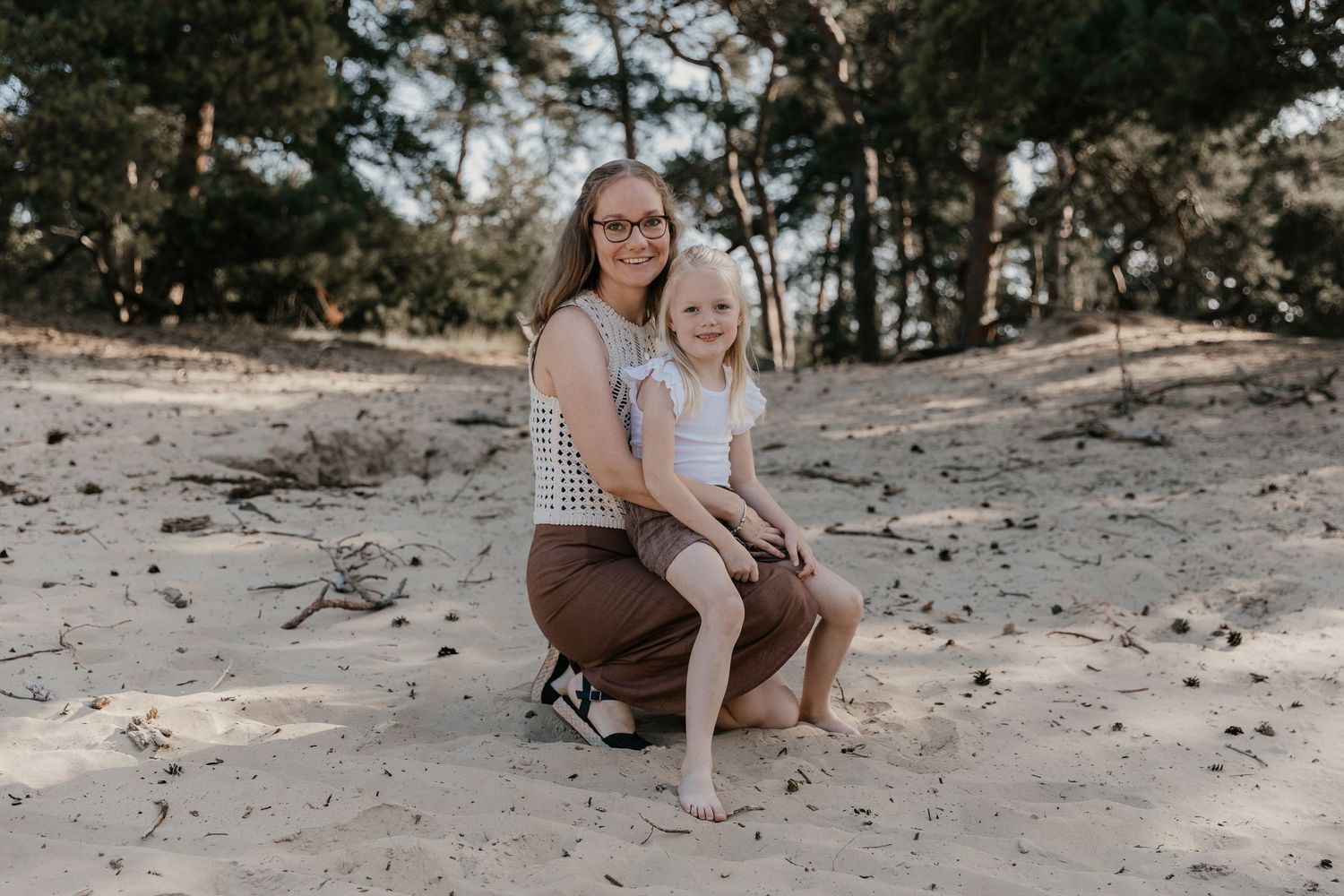 Een ontspannen gezinsmoment tijdens een familieshoot in het Wekeromse Zand, waar liefde, verbinding en plezier centraal staan.