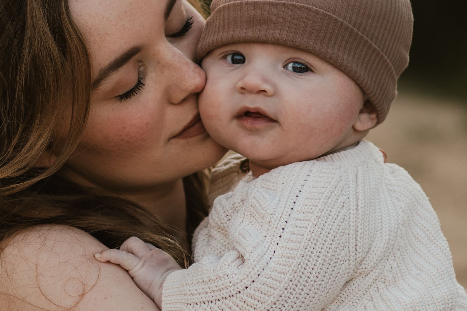 Een warm en intiem moment tussen moeder en baby bij het Wekeromse Zand, waar liefde en verbinding centraal staan.