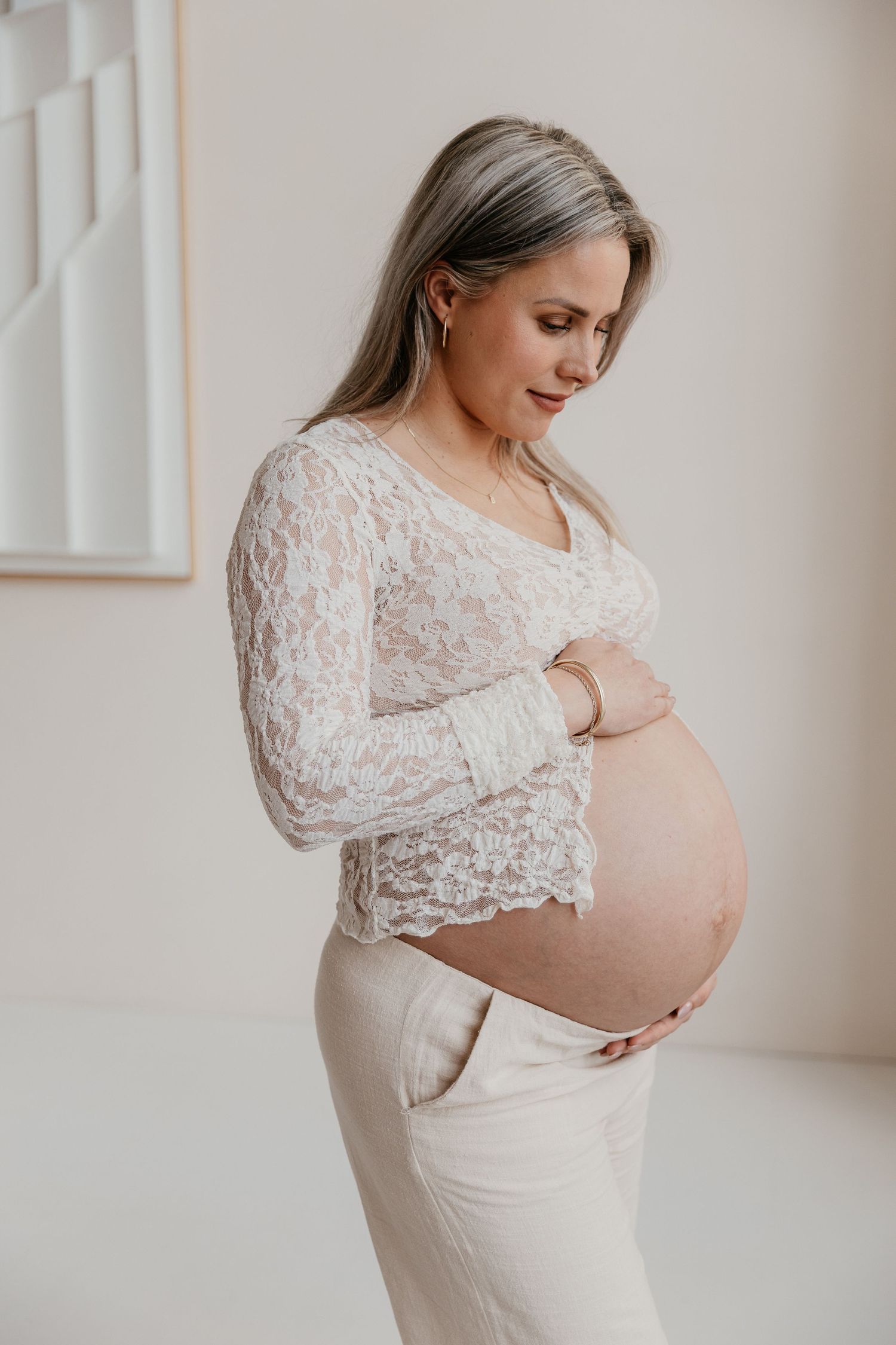 Een aanstaande mama geniet van haar zwangerschap tijdens een liefdevolle fotoshoot in een studio, een bijzonder moment.
