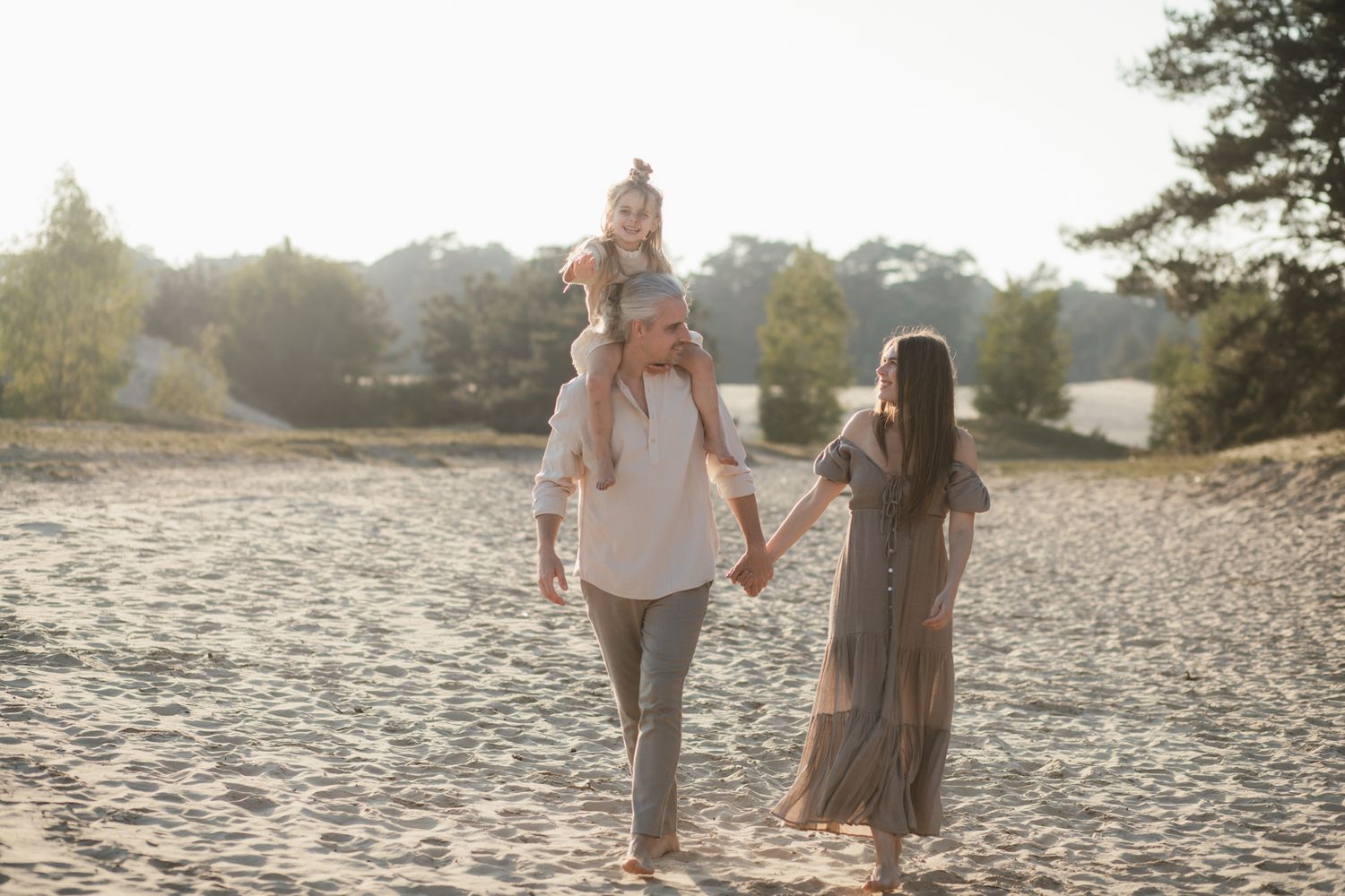 Een ontspannen gezinsmoment tijdens een familieshoot in het Wekeromse Zand, waar liefde, verbinding en plezier centraal staan.