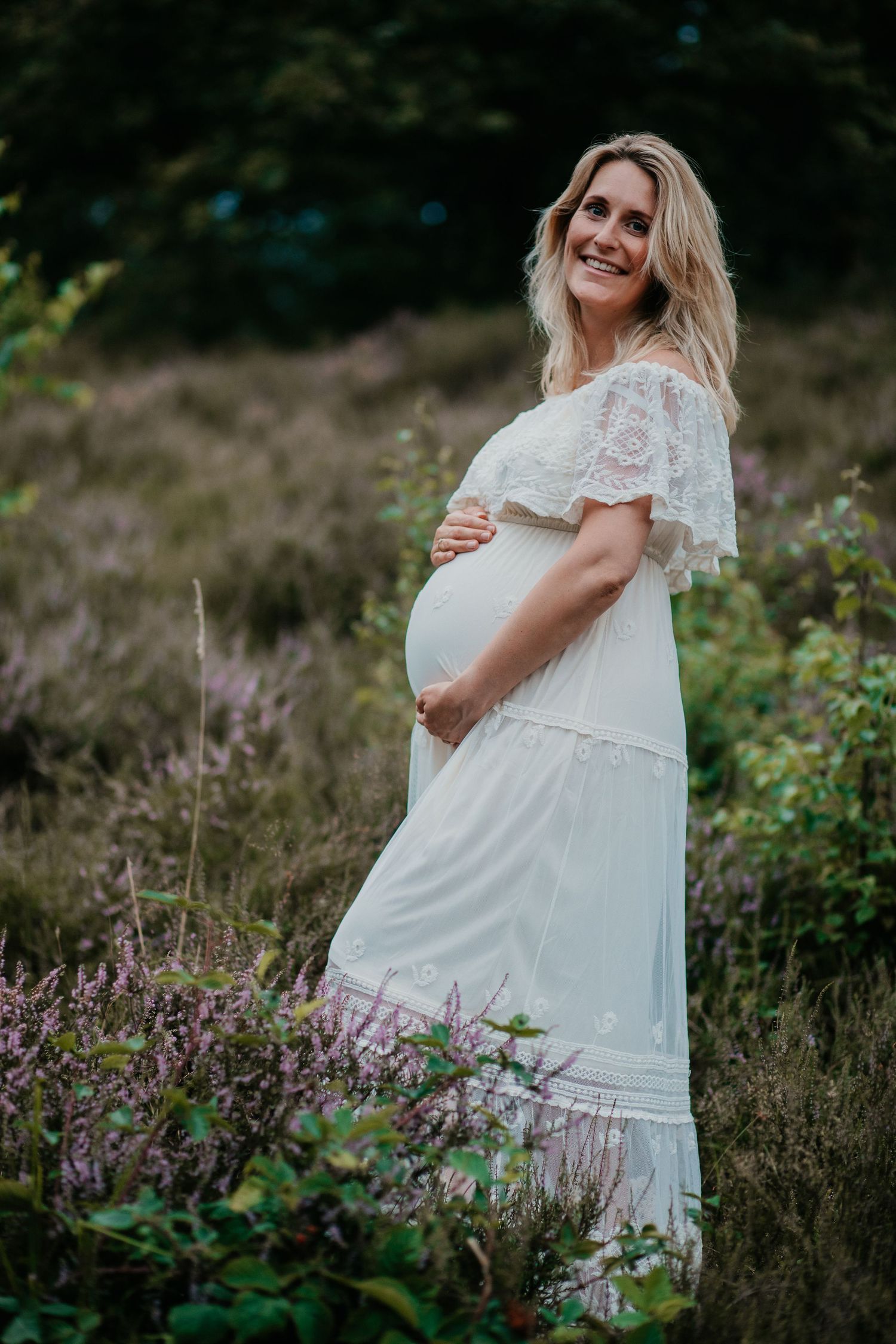 Een aanstaande mama straalt tijdens een warme zwangerschapsshoot in de natuur, een bijzonder moment vol verwachting
