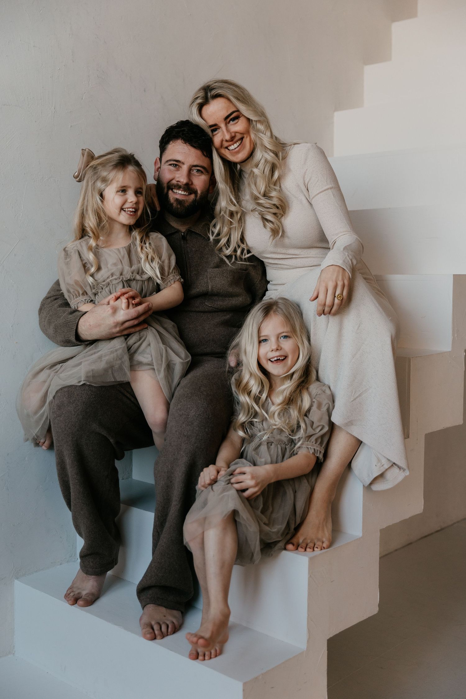 Een liefdevol gezinsmoment tijdens een fotoshoot in een studio waarbij verbinding en samenzijn centraal staan.