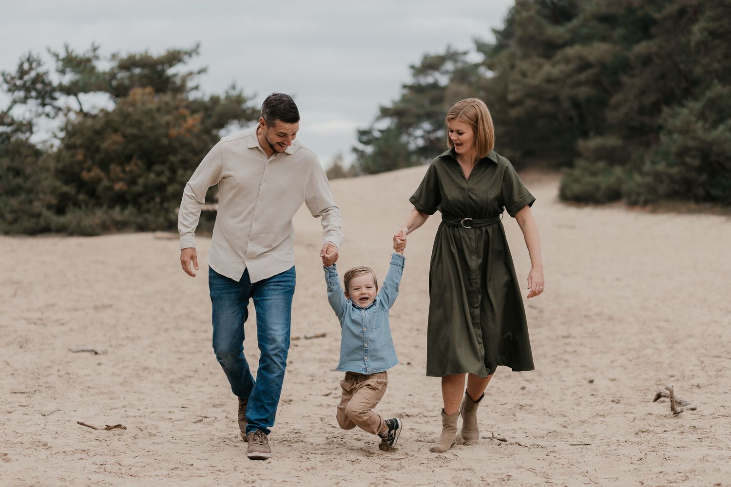 Een ontspannen gezinsmoment tijdens een familieshoot in het Wekeromse Zand, waar liefde, verbinding en plezier centraal staan.
