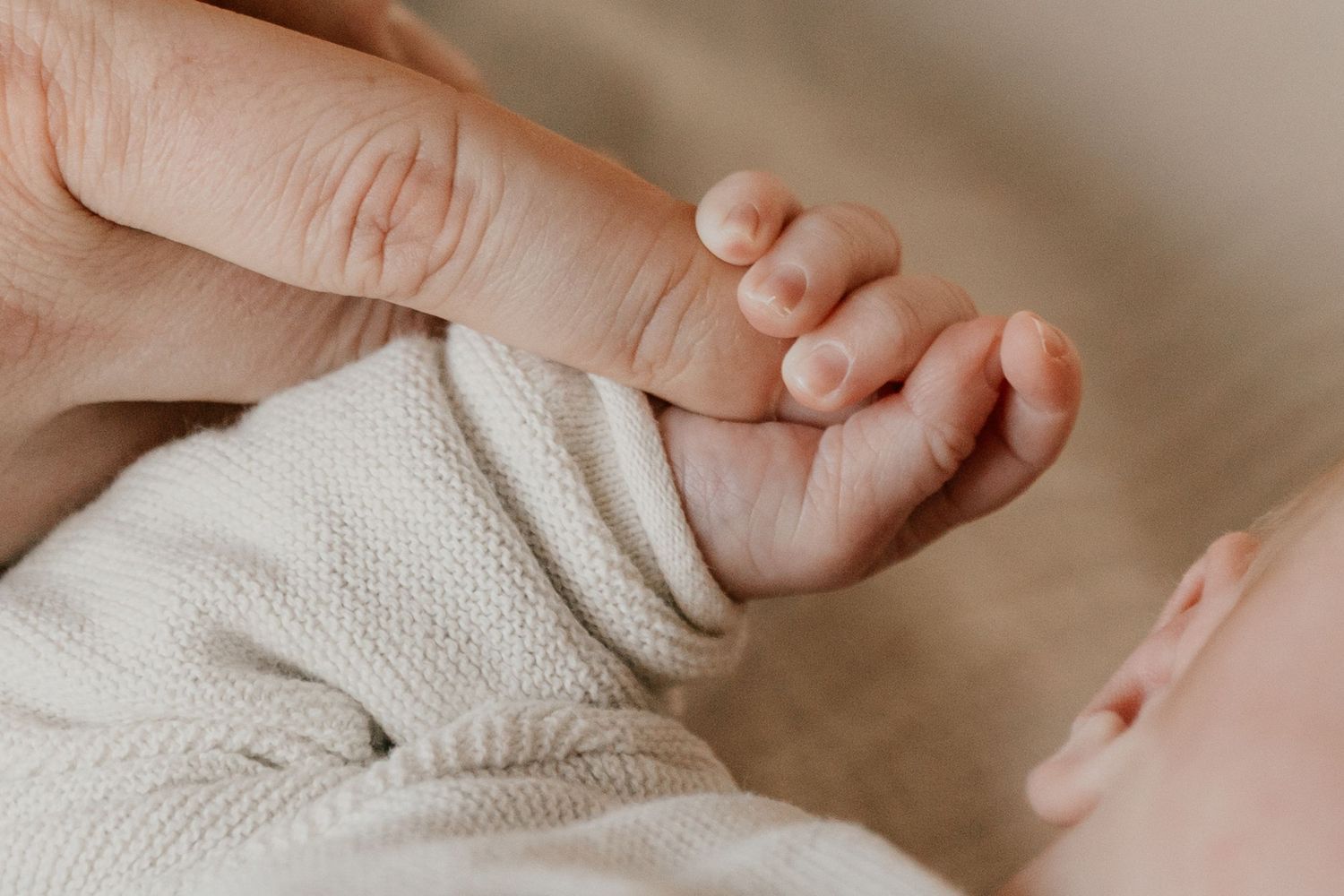 Newborn baby tijdens een ontspannen fotoshoot aan huis, waarbij de warme en vertrouwde omgeving van het gezin wordt vastgelegd.