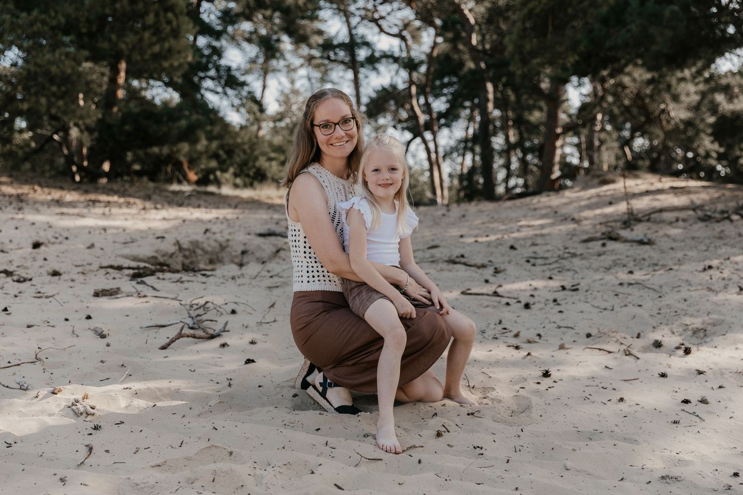 Een ontspannen gezinsmoment tijdens een familieshoot in het Wekeromse Zand, waar liefde, verbinding en plezier centraal staan.