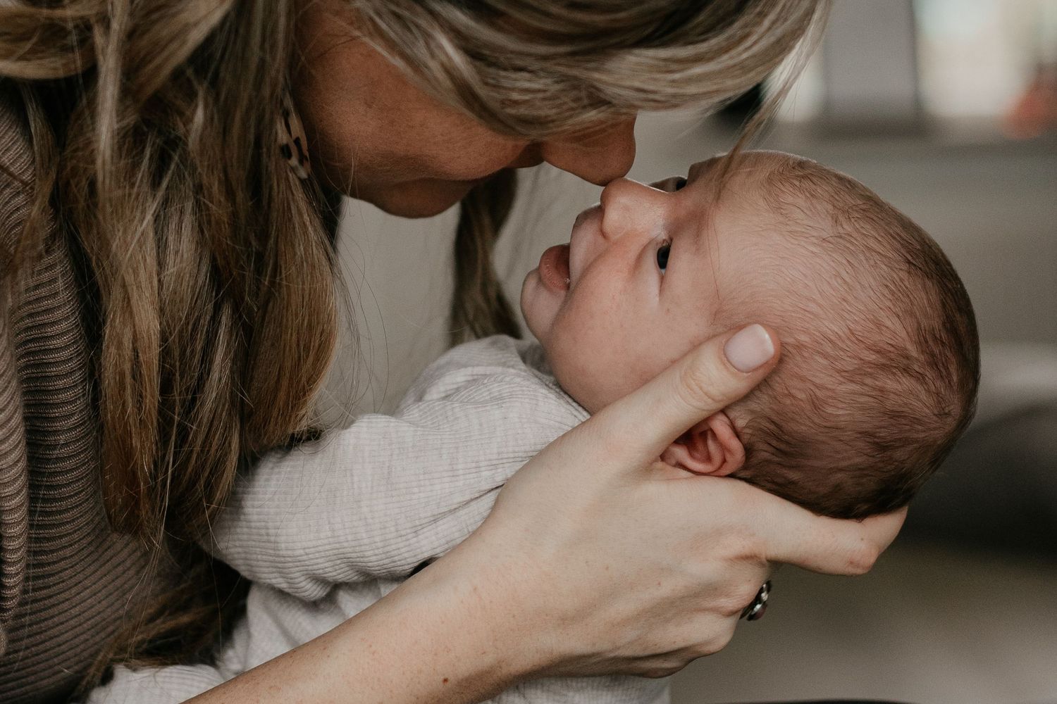 Newborn baby tijdens een ontspannen fotoshoot aan huis, waarbij de warme en vertrouwde omgeving van het gezin wordt vastgelegd.