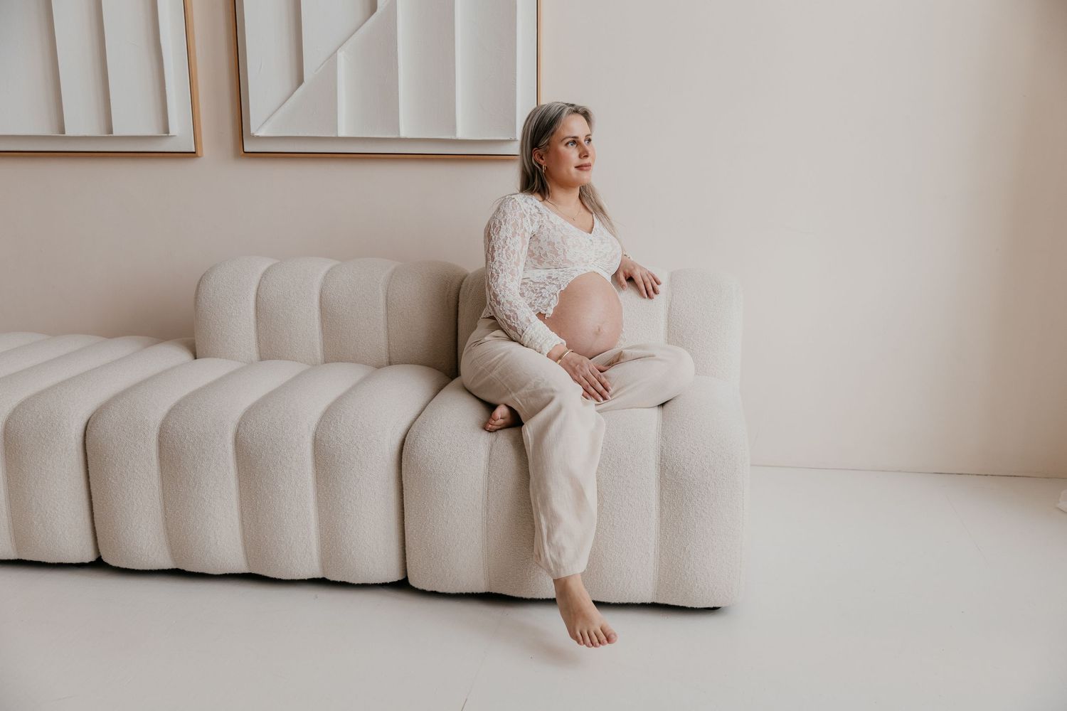 Een aanstaande mama geniet van haar zwangerschap tijdens een liefdevolle fotoshoot in een studio, een bijzonder moment.