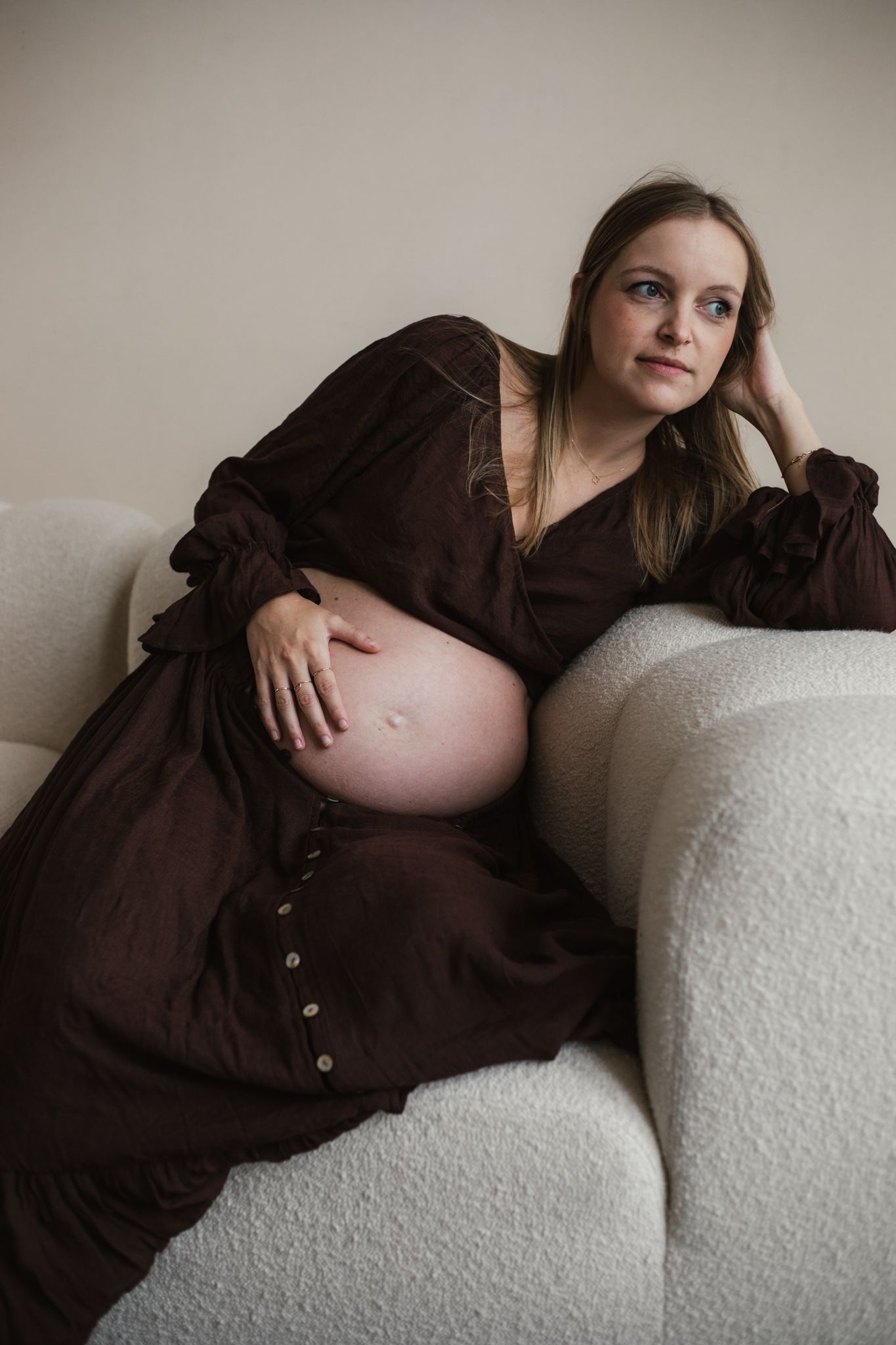 Een aanstaande mama geniet van haar zwangerschap tijdens een liefdevolle fotoshoot in een studio, een bijzonder moment.