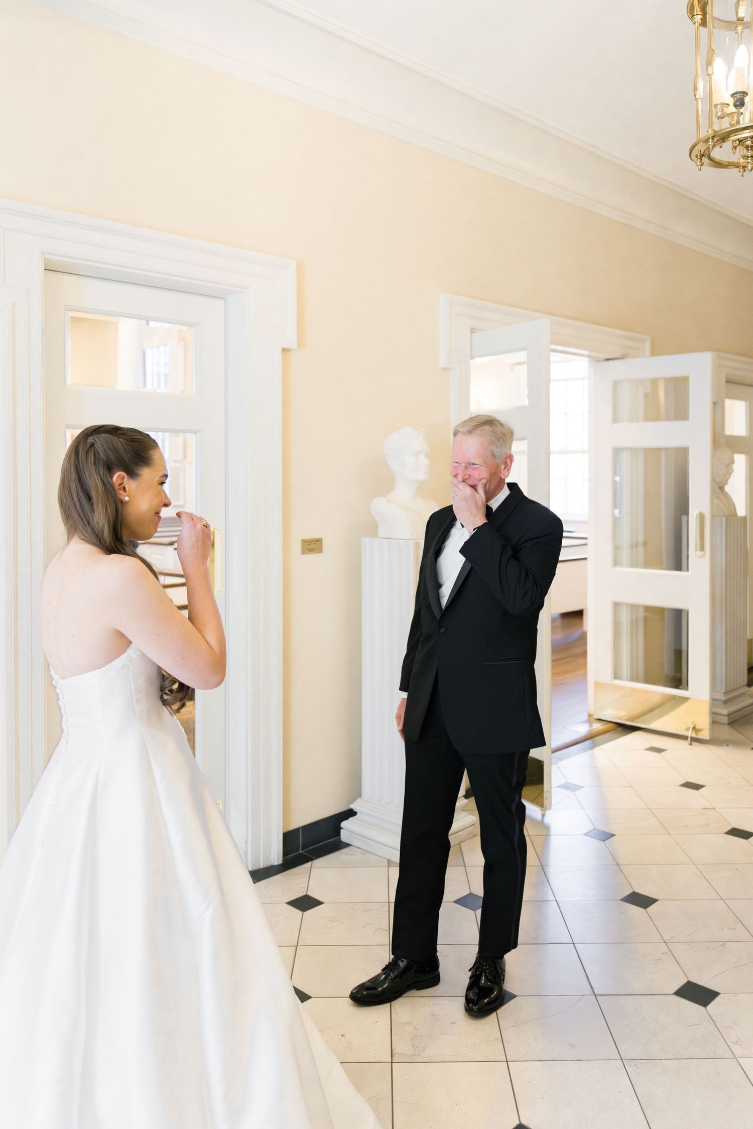 Emotional father wipes tears seeing his daughter in her wedding dress for the first time.