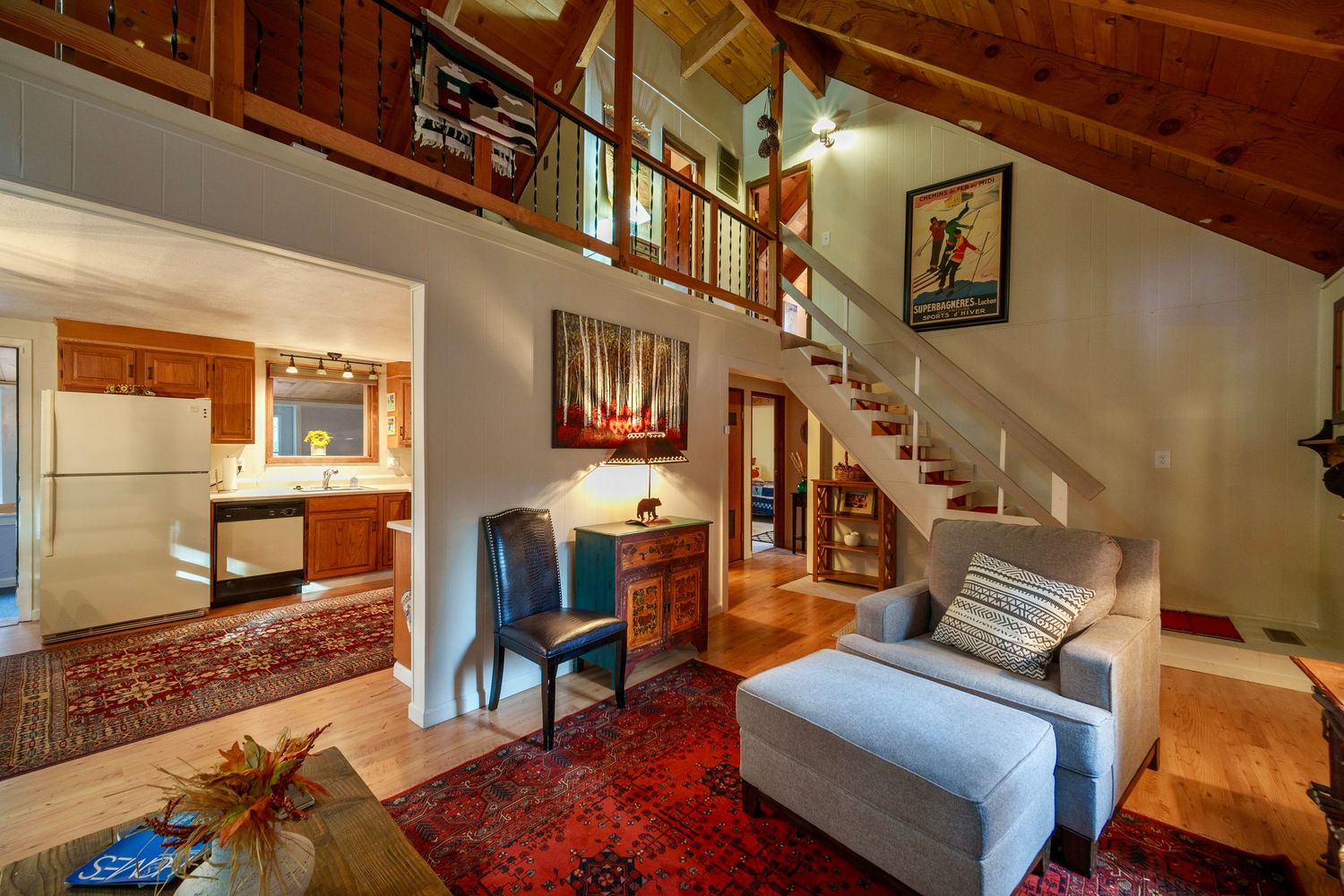Modern loft-style bedroom with exposed brick walls, wooden beams, and a cozy gray sofa in a renovated urban space.