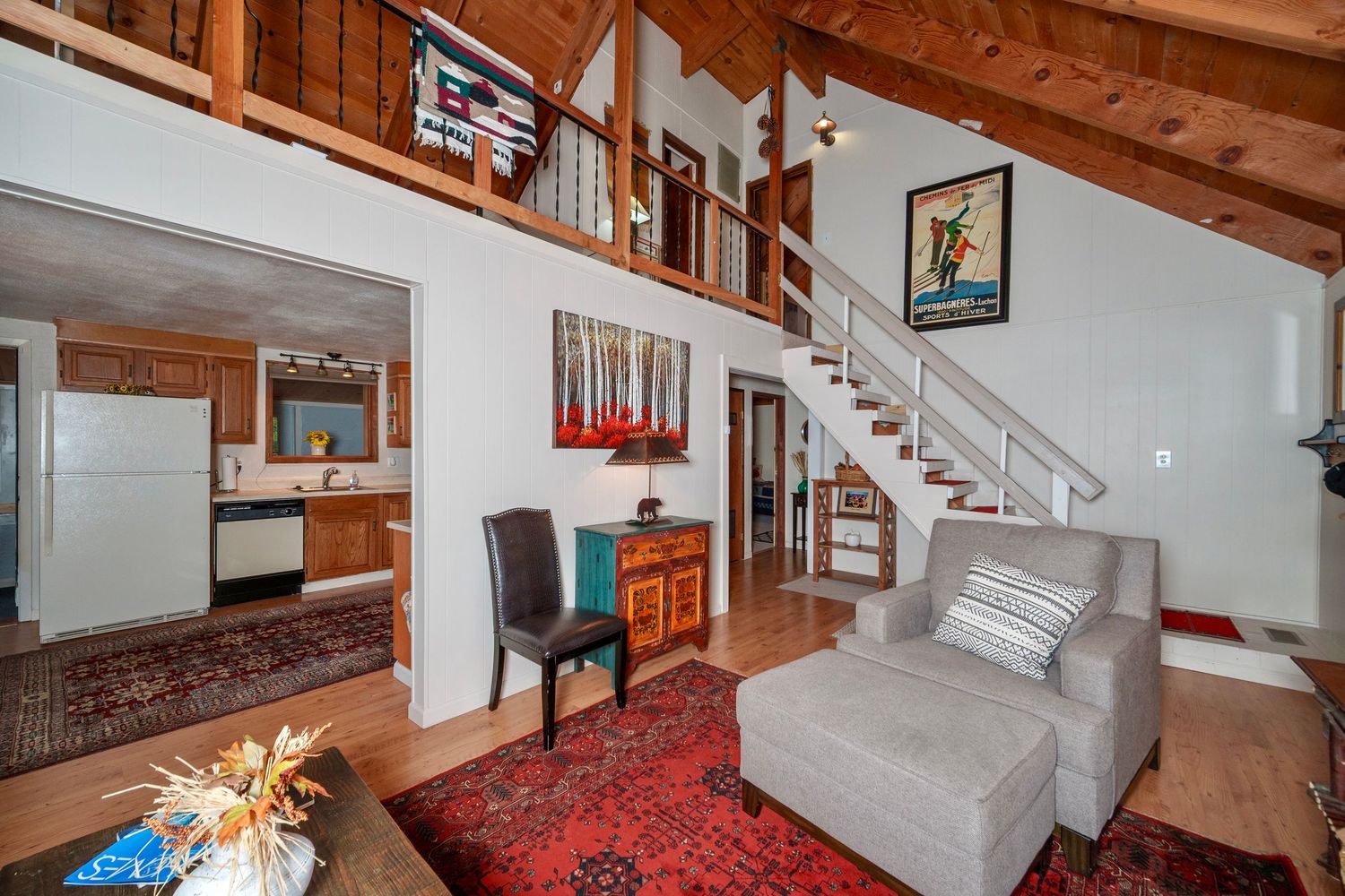 Modern townhouse interior features exposed wooden beams, brick accent walls, and an open staircase design.