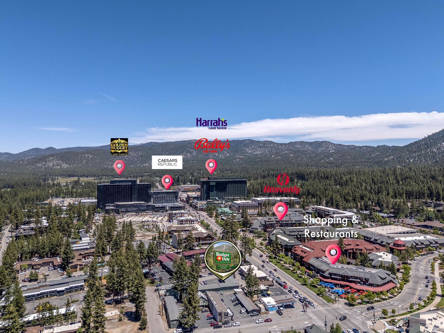 Aerial view of South Lake Tahoe casino district featuring Harrahs and Harveys hotels surrounded by pine trees and mountains.
