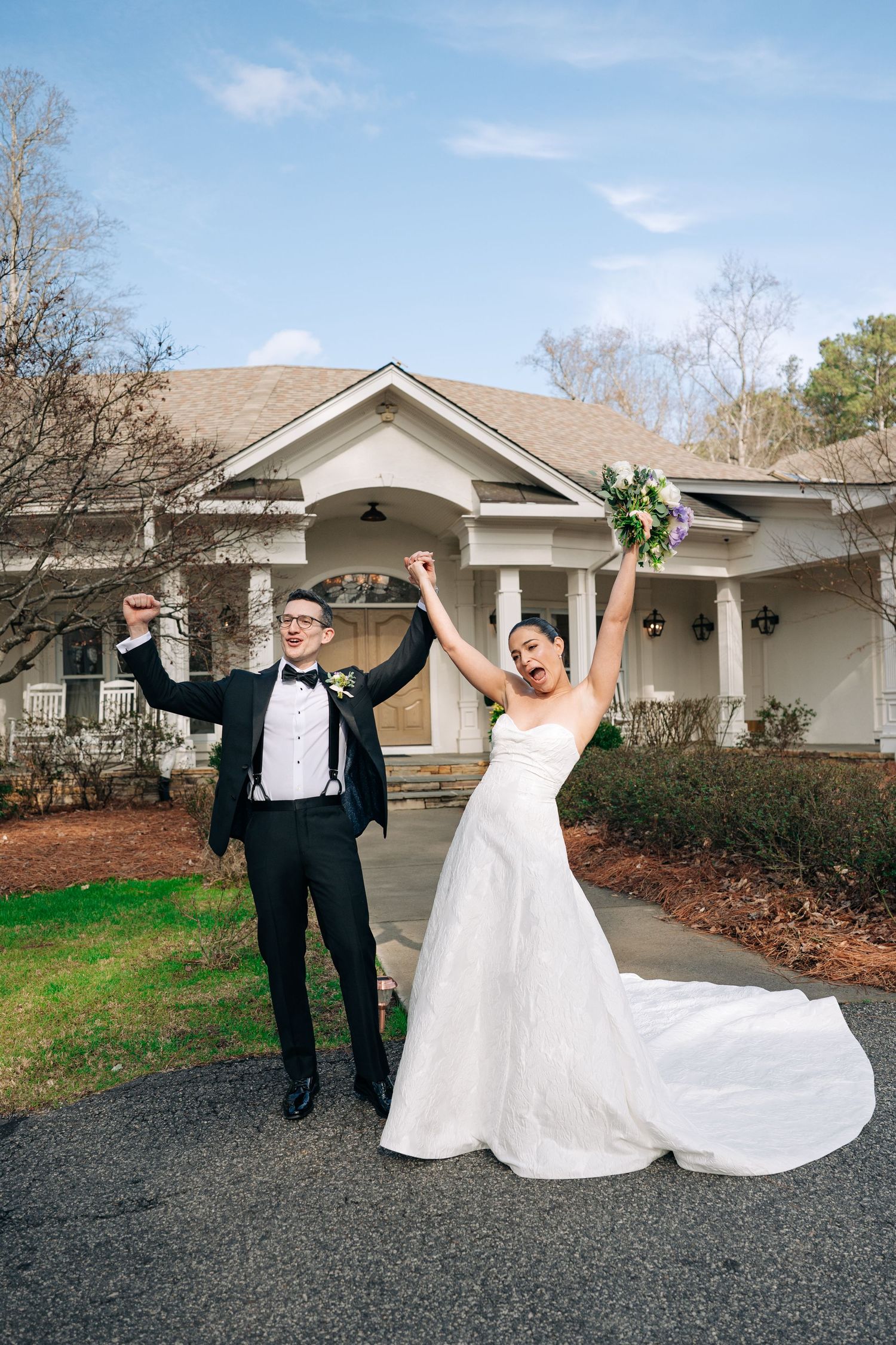 Joyful bride and groom celebrating outside wedding venue with arms raised at Little River Farms in Alpharetta, Georiga.