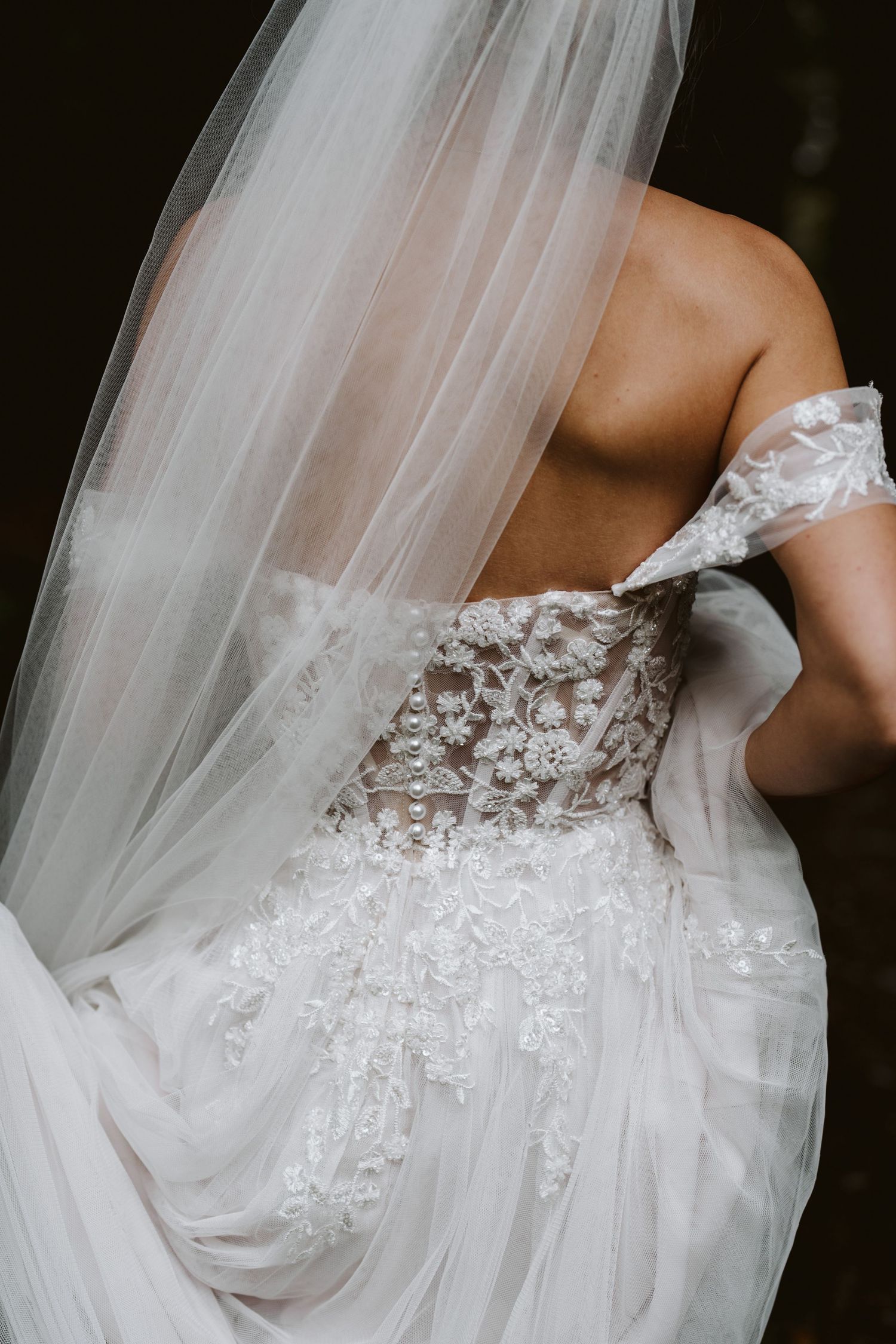 Braut mit Schleier und Spitzenkleid von hinten