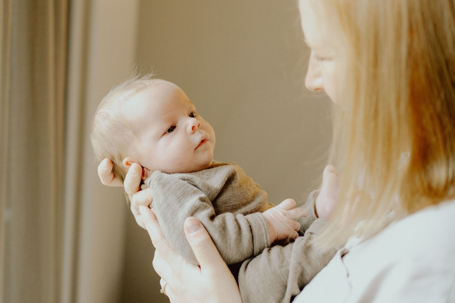 Mutter hält ihr Baby am Fenster