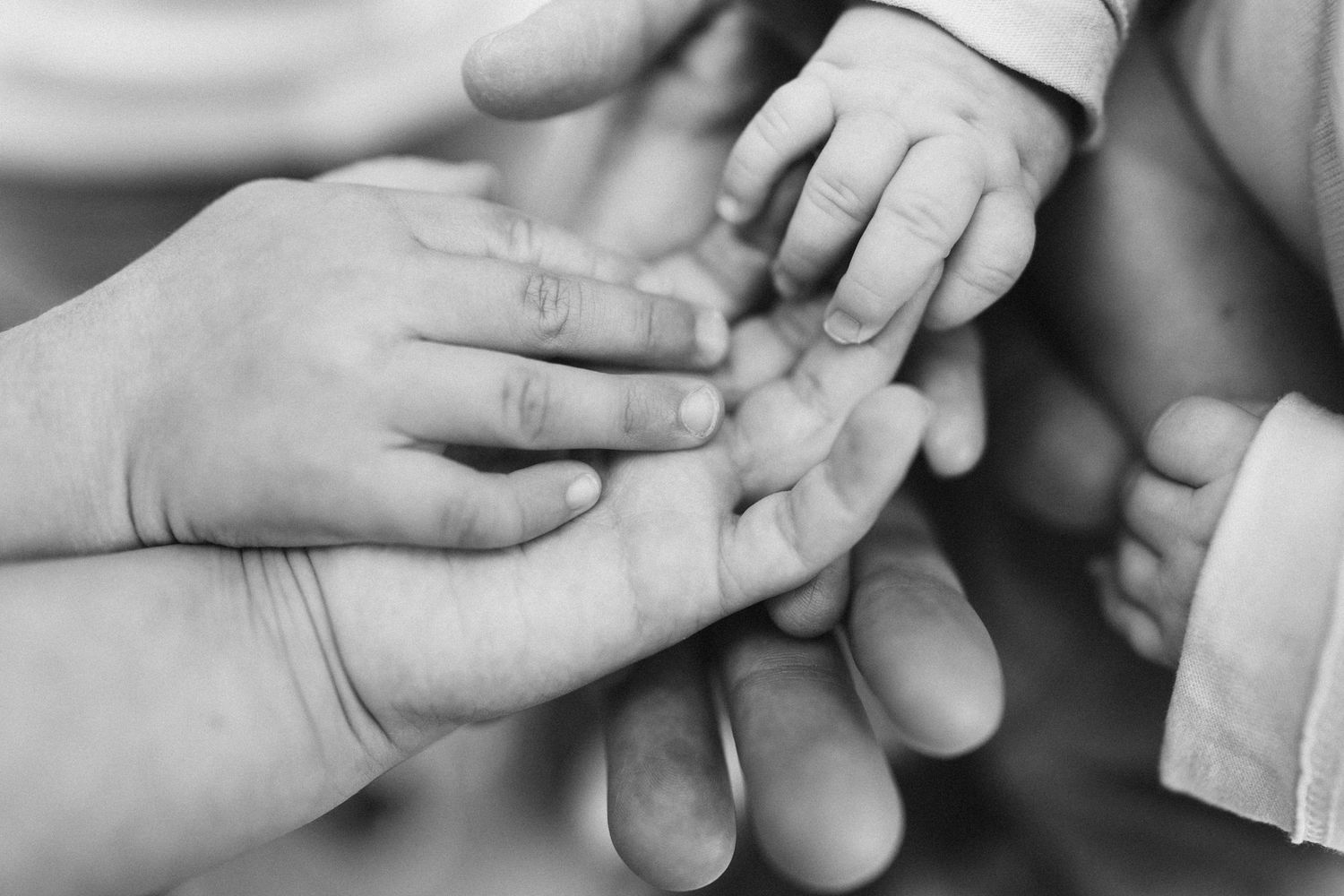 Babyhand in den Händen der Eltern, Schwarzweiß