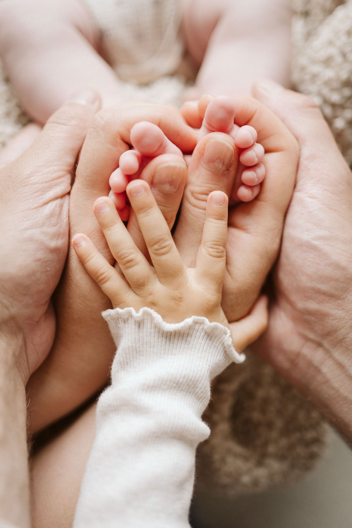 Babyfüße in den Händen der Eltern, Newborn-Shooting