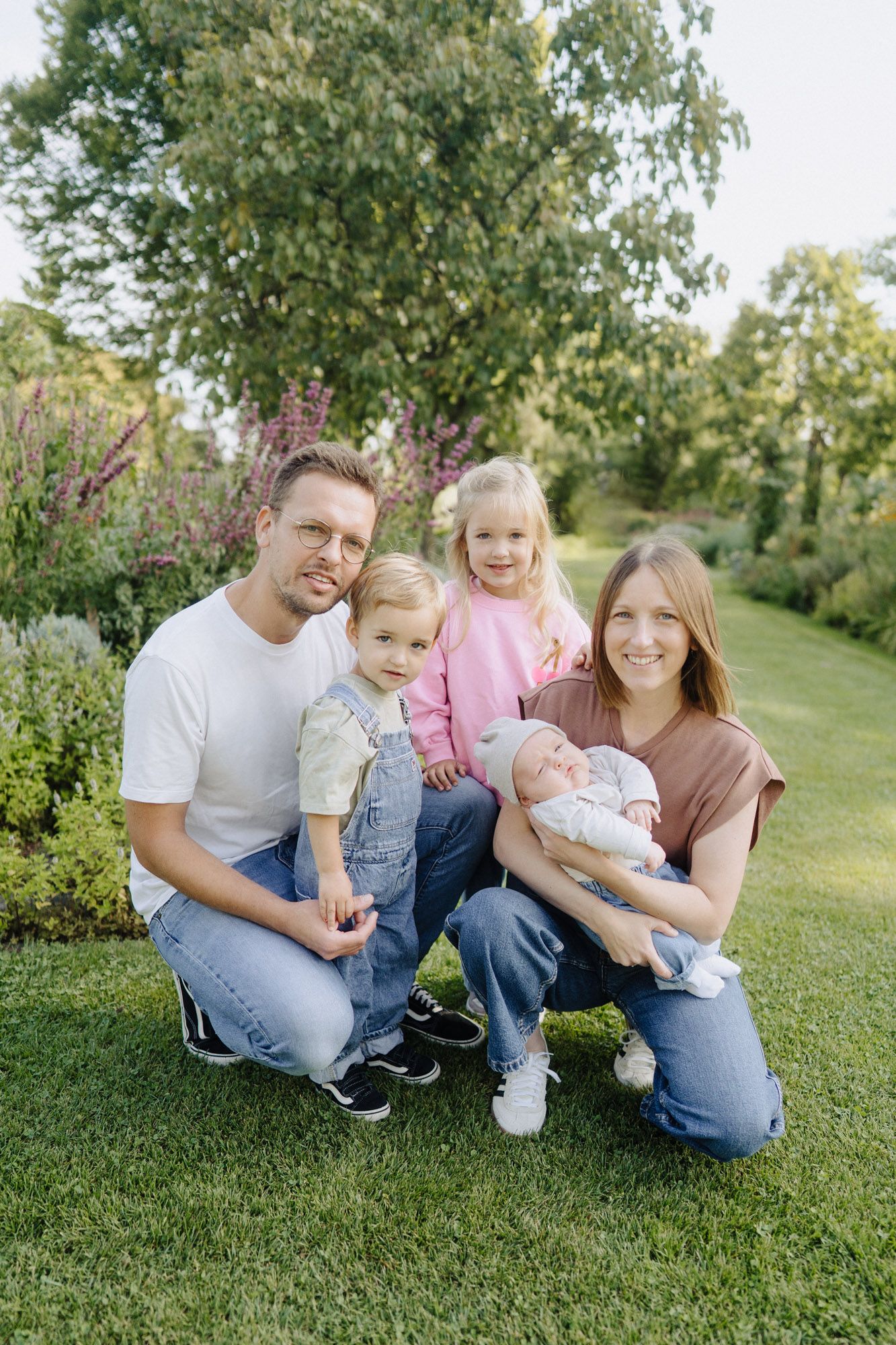 Familie mit zwei Kindern auf dem Rasen, Familien-Shooting