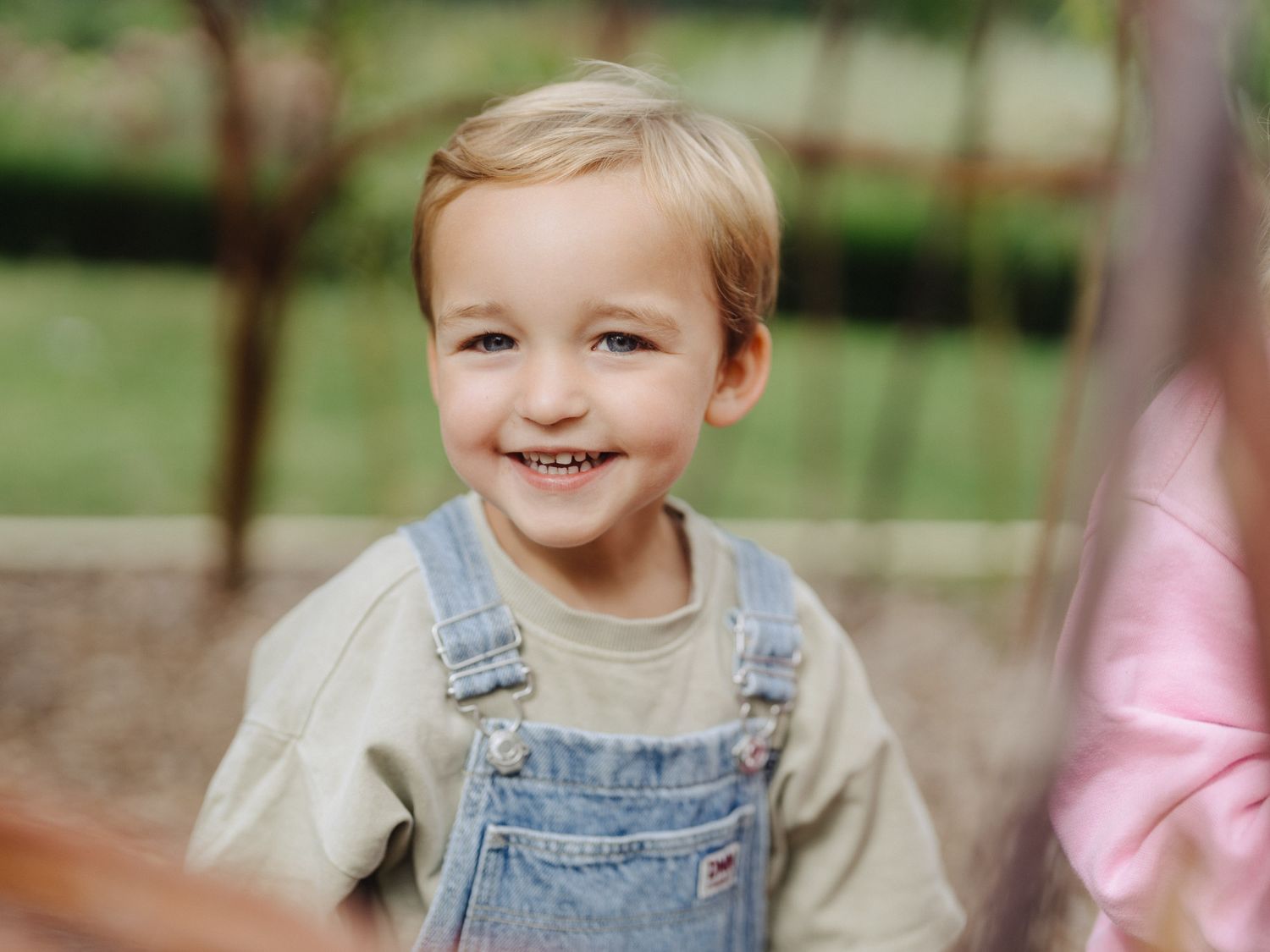 Lachender kleiner Junge in Latzhose